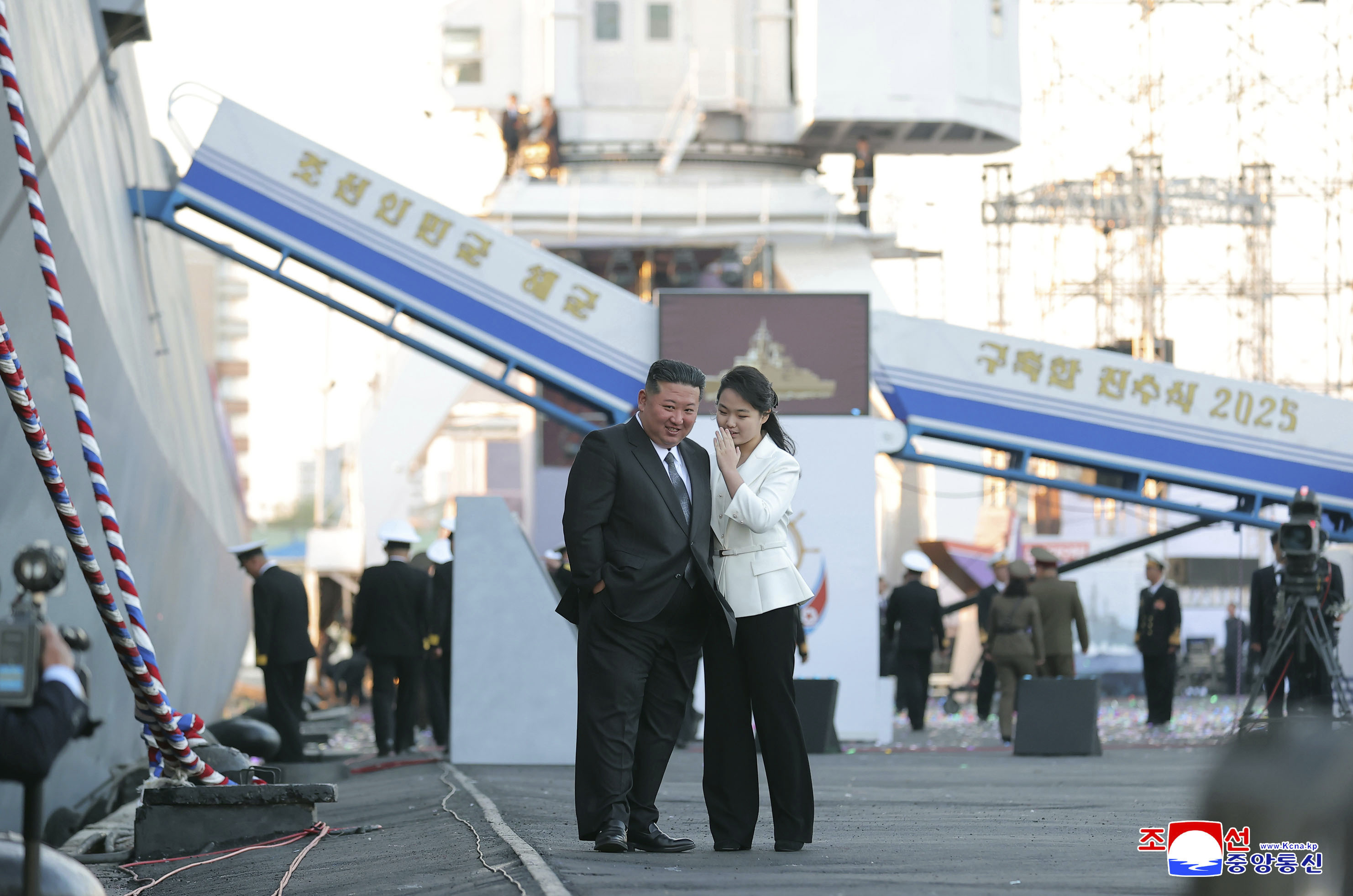 In this photo provided by the North Korean government, its leader Kim Jong Un's daughter talks to him on the day of a launching ceremony for a new naval destroyer at a western port in Nampo, North Korea, Friday, April 25, 2025. 