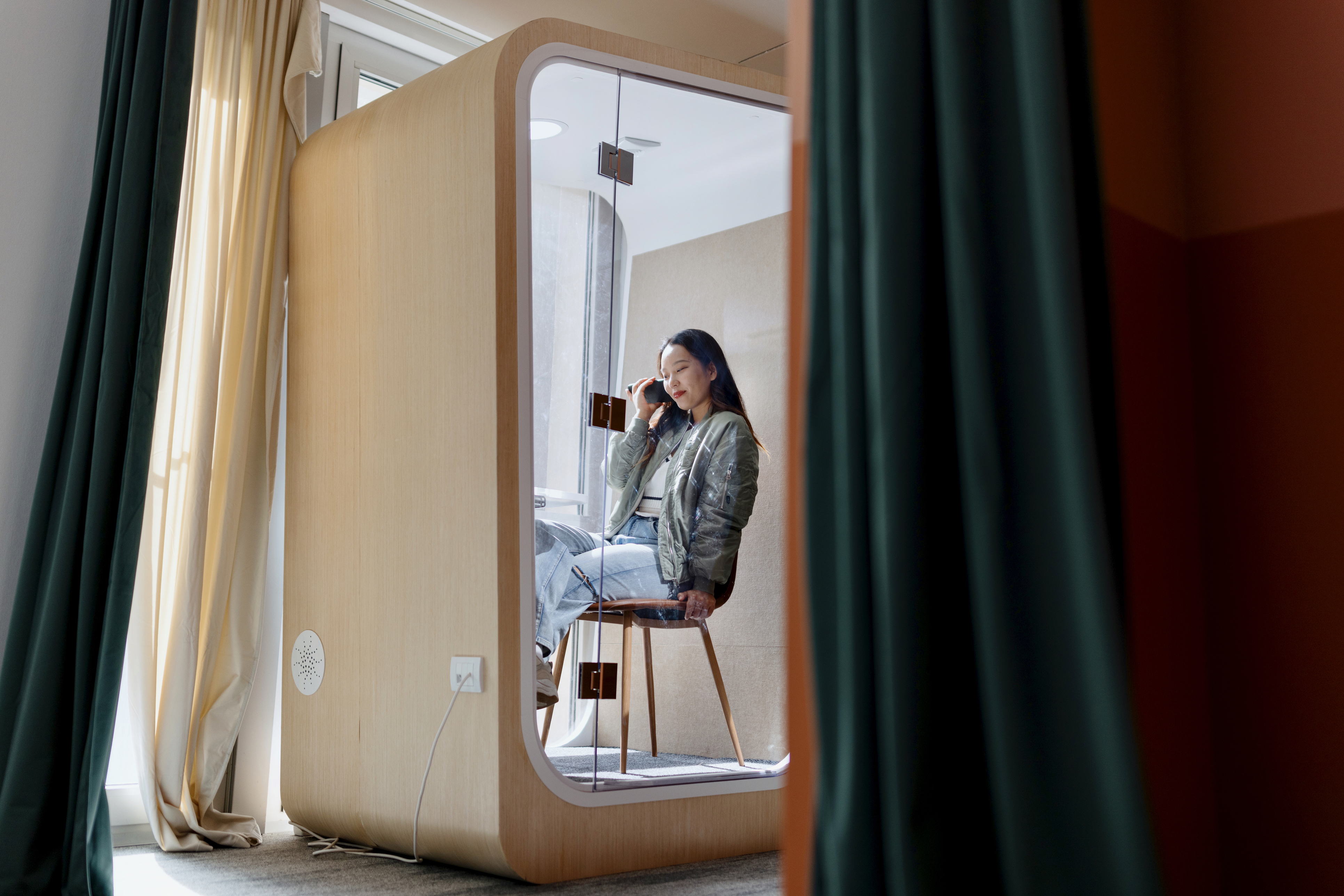 Hybrid workplace, female business professional sitting at desk talking on the phone
