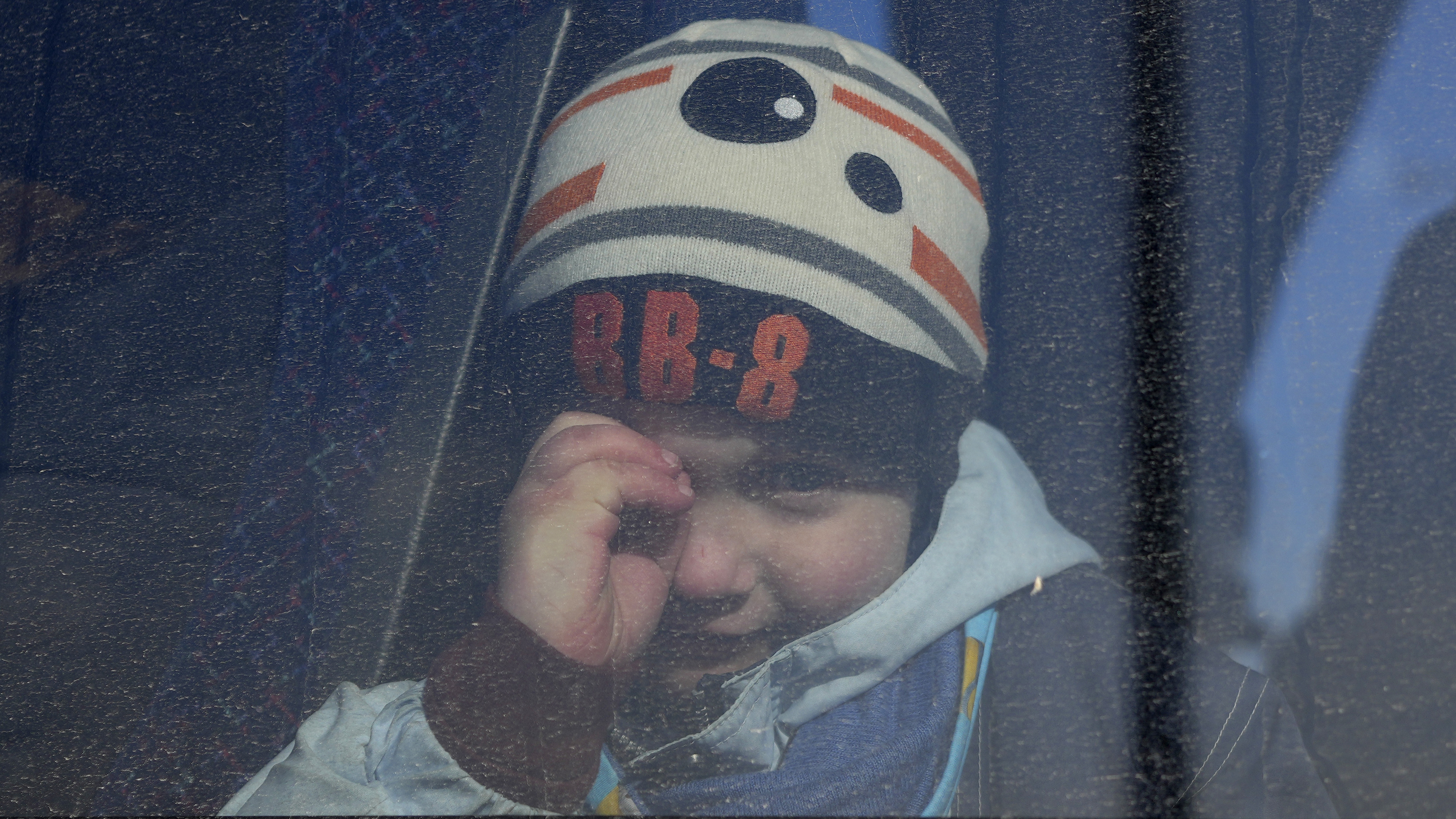 A child looks through a window of a bus carrying refugees fleeing the conflict from neighbouring Ukraine in the border town of Przemysl, Poland.