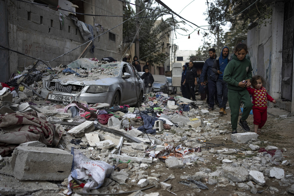 Palestinians look at the destruction after an Israeli airstrike in Rafah, Gaza Strip, Friday, Feb. 9, 2024. 