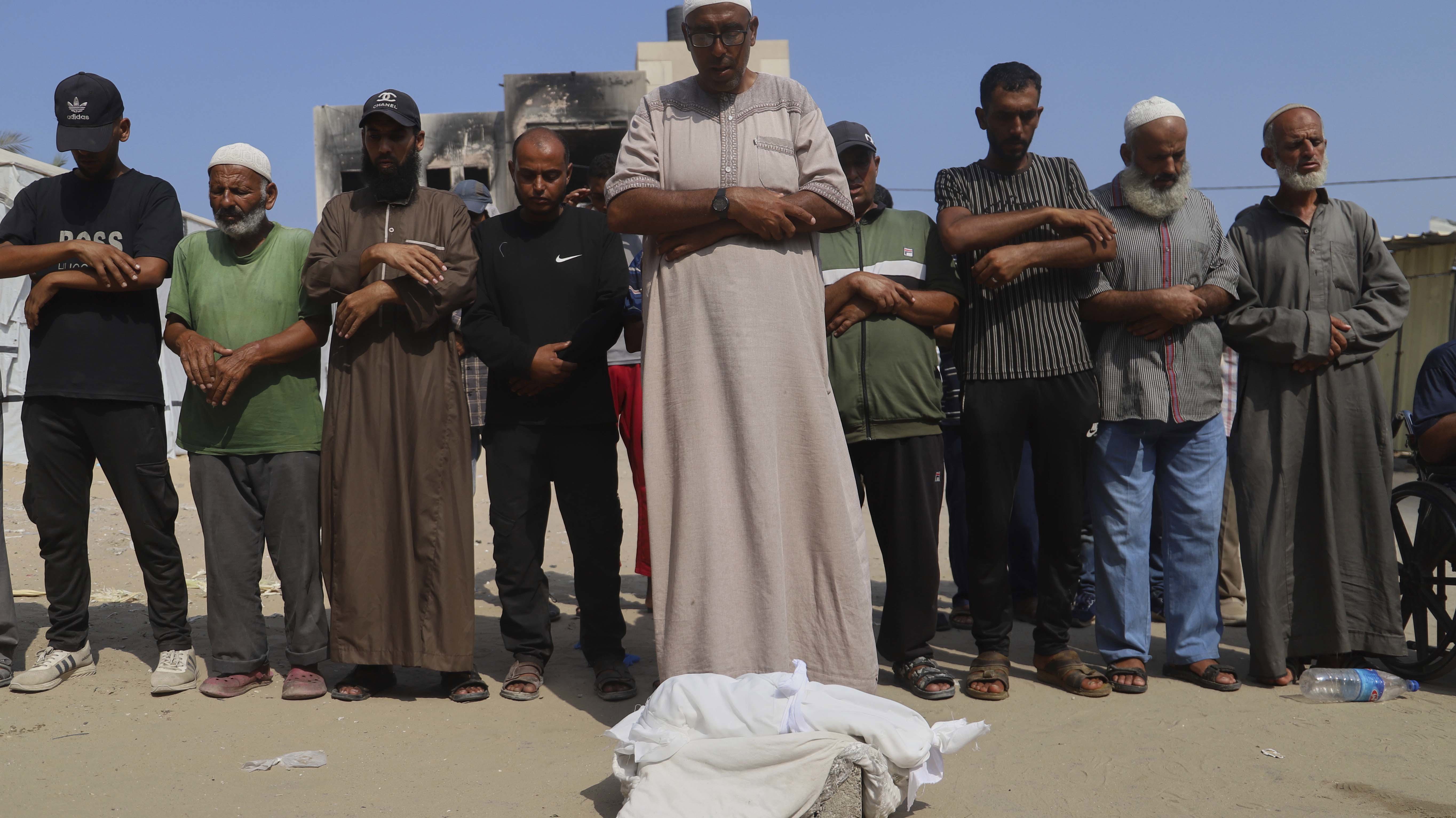 Palestinians pray over the body of five-month-old baby, Zainab Abu Halib, who died from malnutrition-related causes, according to the family and the hospital, during her funeral outside the Nasser Hospital, Gaza.