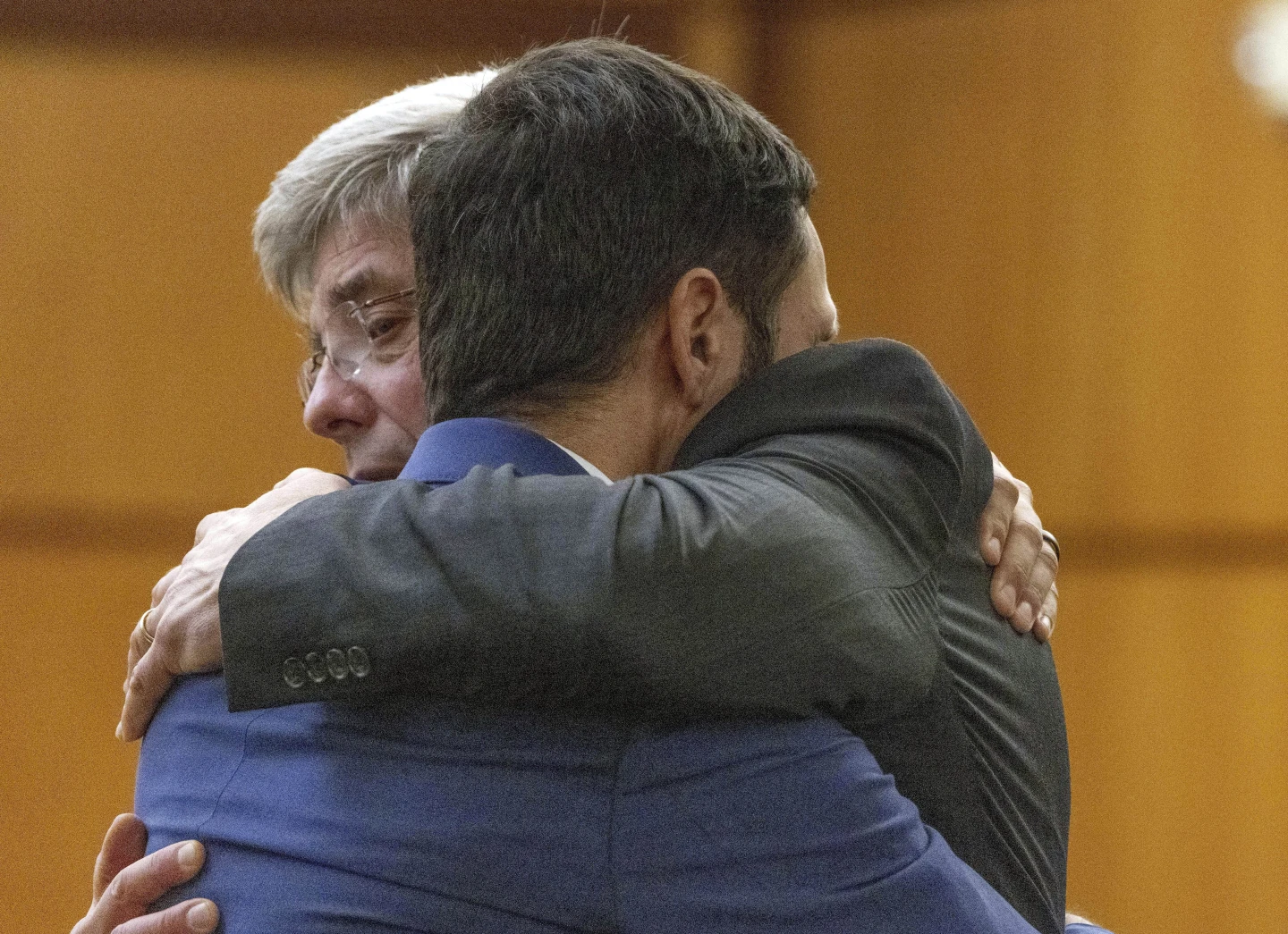 El oficial de policía de Tacoma, Christopher Burbank, recibe un abrazo de su abogado Wayne Fricke.