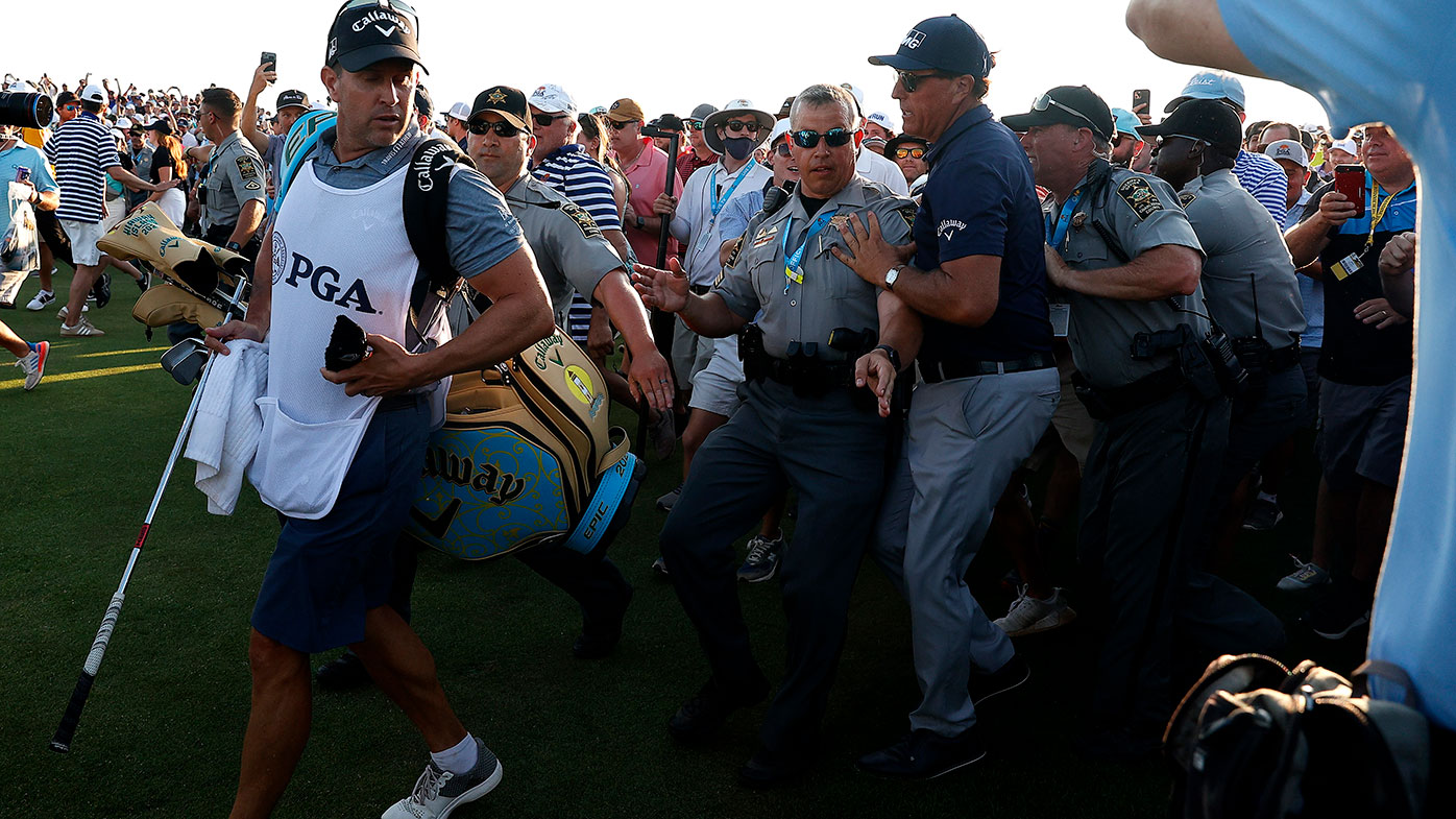 Security pushes Phil Mickelson through the crowd on the final hole of the PGA Championship at Kiawah Island.