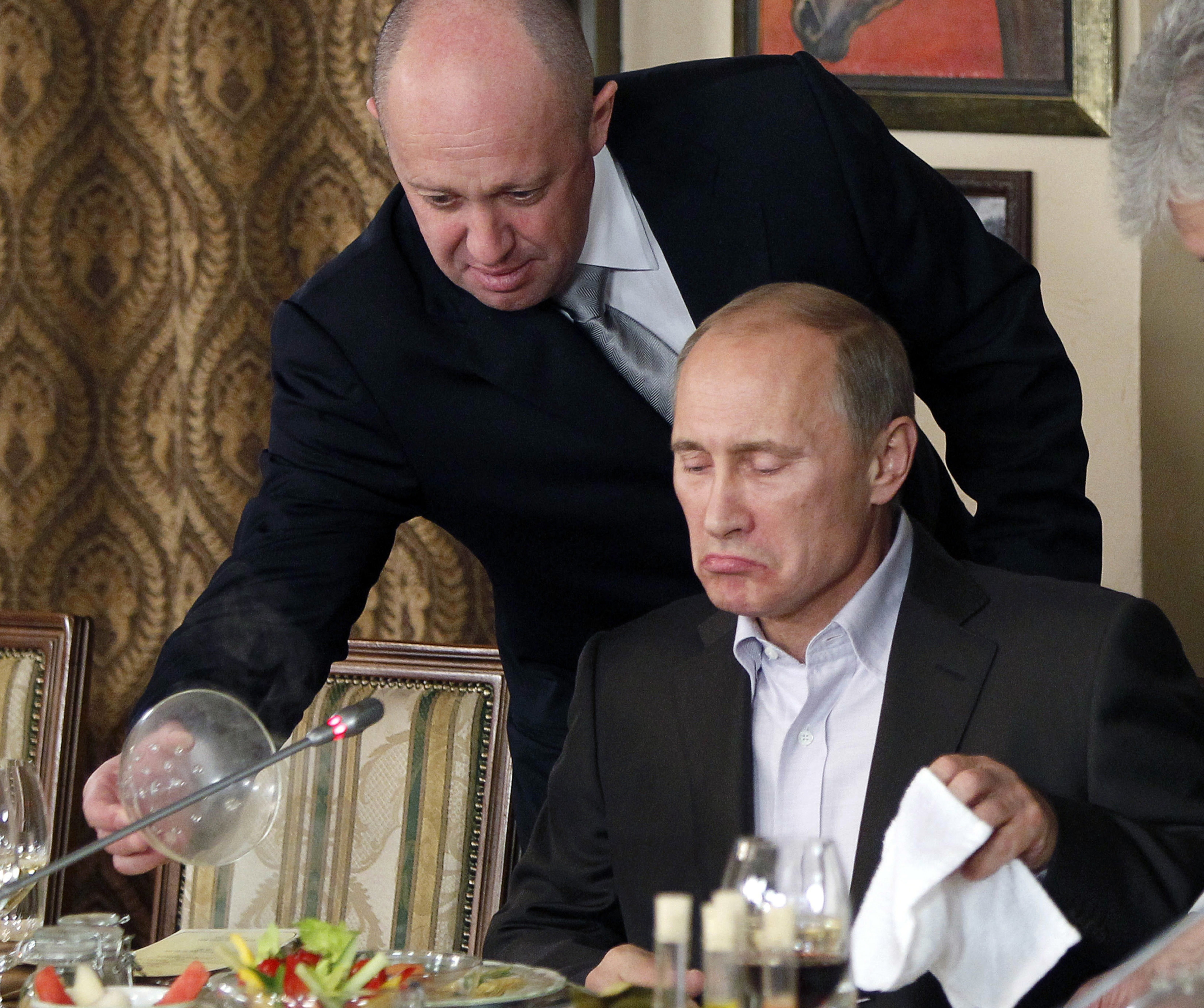 FILE Yevgeny Prigozhin, top, serves food to then-Russian Prime Minister Vladimir Putin at Prigozhin's restaurant outside Moscow, Russia on Nov. 11, 2011. Prigozhin, the owner of the Wagner private military contractor who called for an armed rebellion aimed at ousting Russia's defense minister has confirmed in a video that he and his troops have reached Rostov-on-Don. 