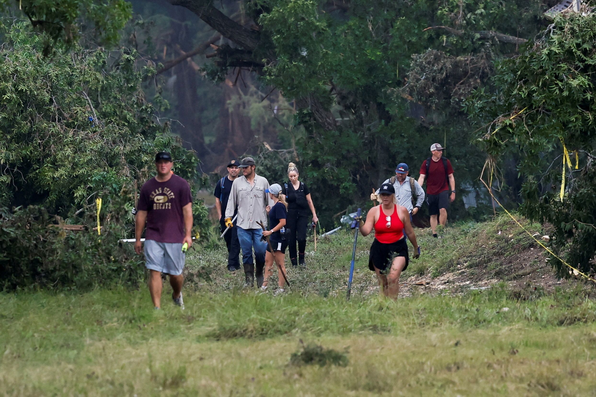 * People search the area in Hunt, Texas, on July 6.