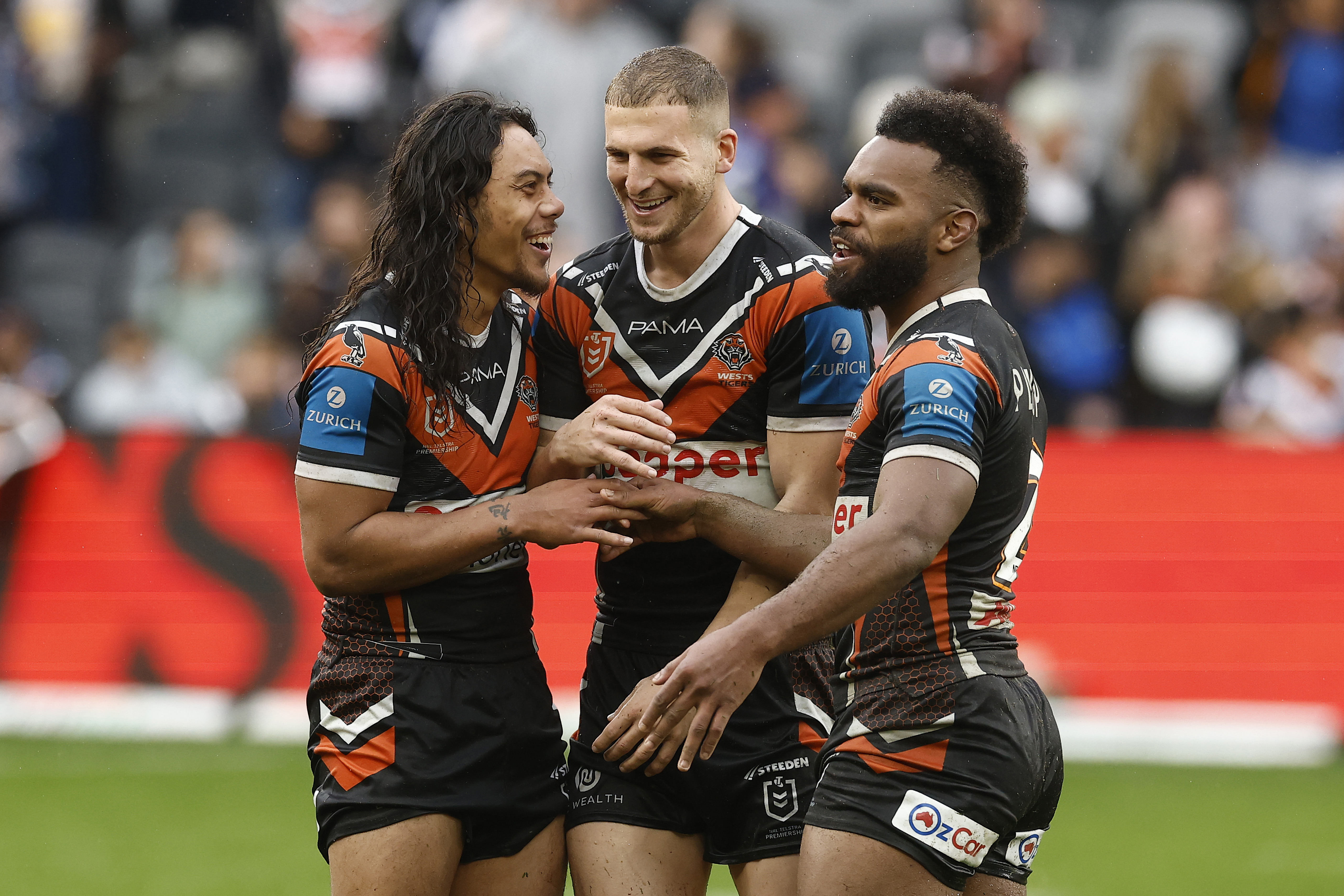 SYDNEY, AUSTRALIA - AUGUST 03: Jarome Luai, Adam Doueihi and Sunia Turuva of the Wests Tigers celebrate victory during the round 22 NRL match between Wests Tigers and Canterbury Bulldogs at CommBank Stadium, on August 03, 2025, in Sydney, Australia. (Photo by Mark Evans/Getty Images)