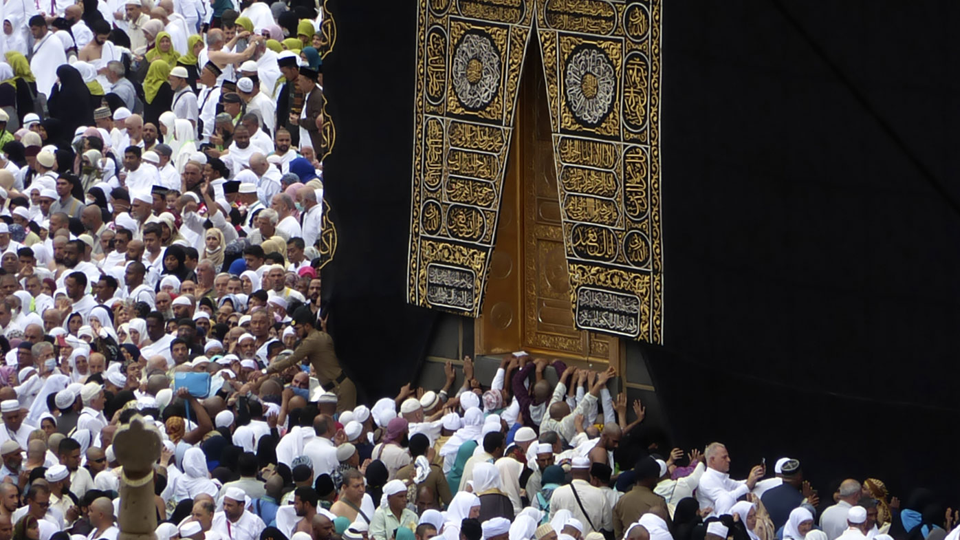 In this Feb. 24, 2020, photo, Muslim pilgrims pray near the Kaaba, the cubic building at the Grand Mosque, as worshippers circumambulate around during the minor pilgrimage, known as Umrah in the Muslim holy city of Mecca