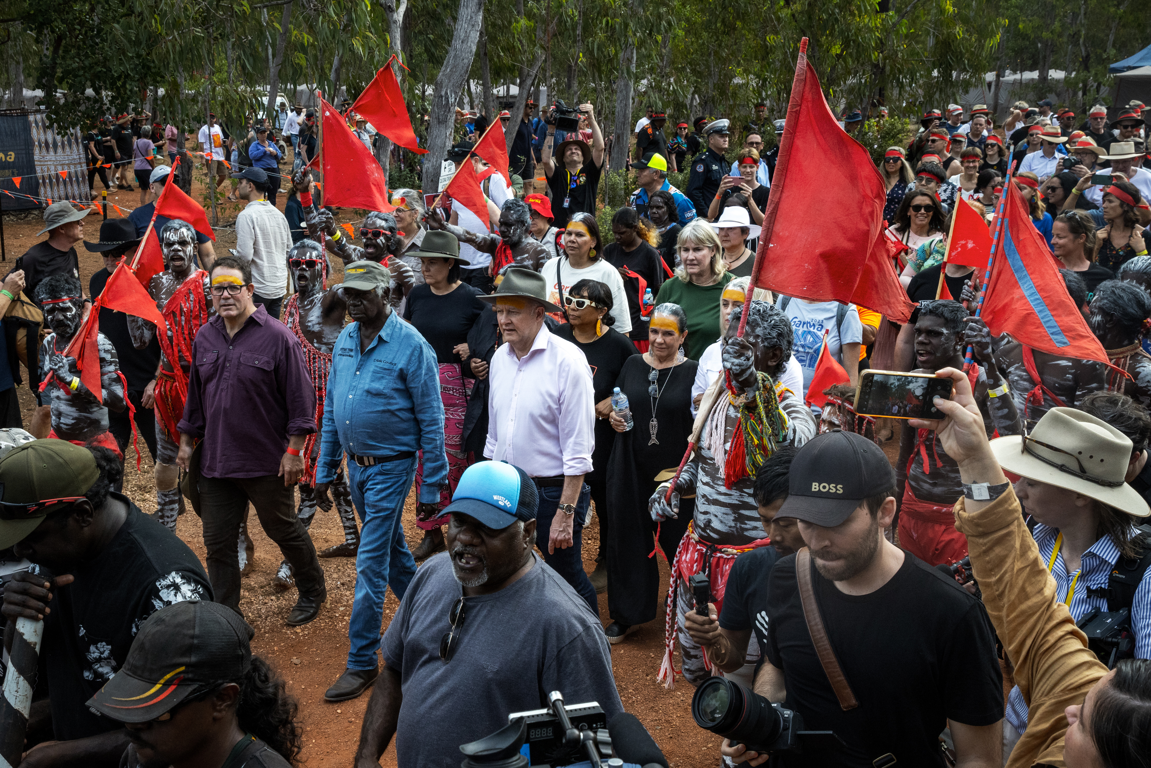 Luke Gosling, Yolngu Elder Djawa Yunupingu and Australian Prime Minister Anthony Albanese are escorted through the Garma Festival