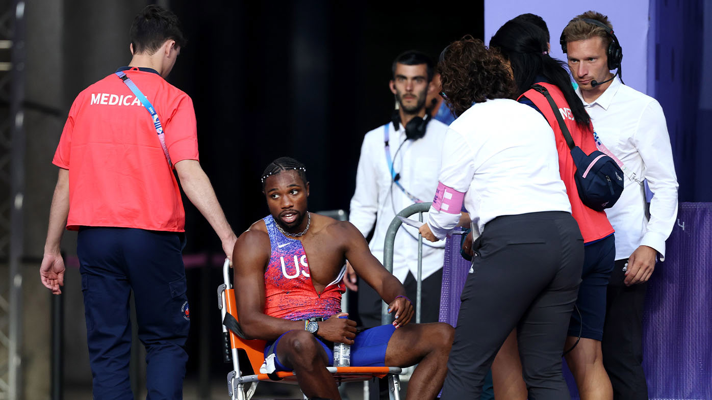 Noah Lyles, struggling with COVID-19, receiving medical attention after the men's Olympic 200m final.