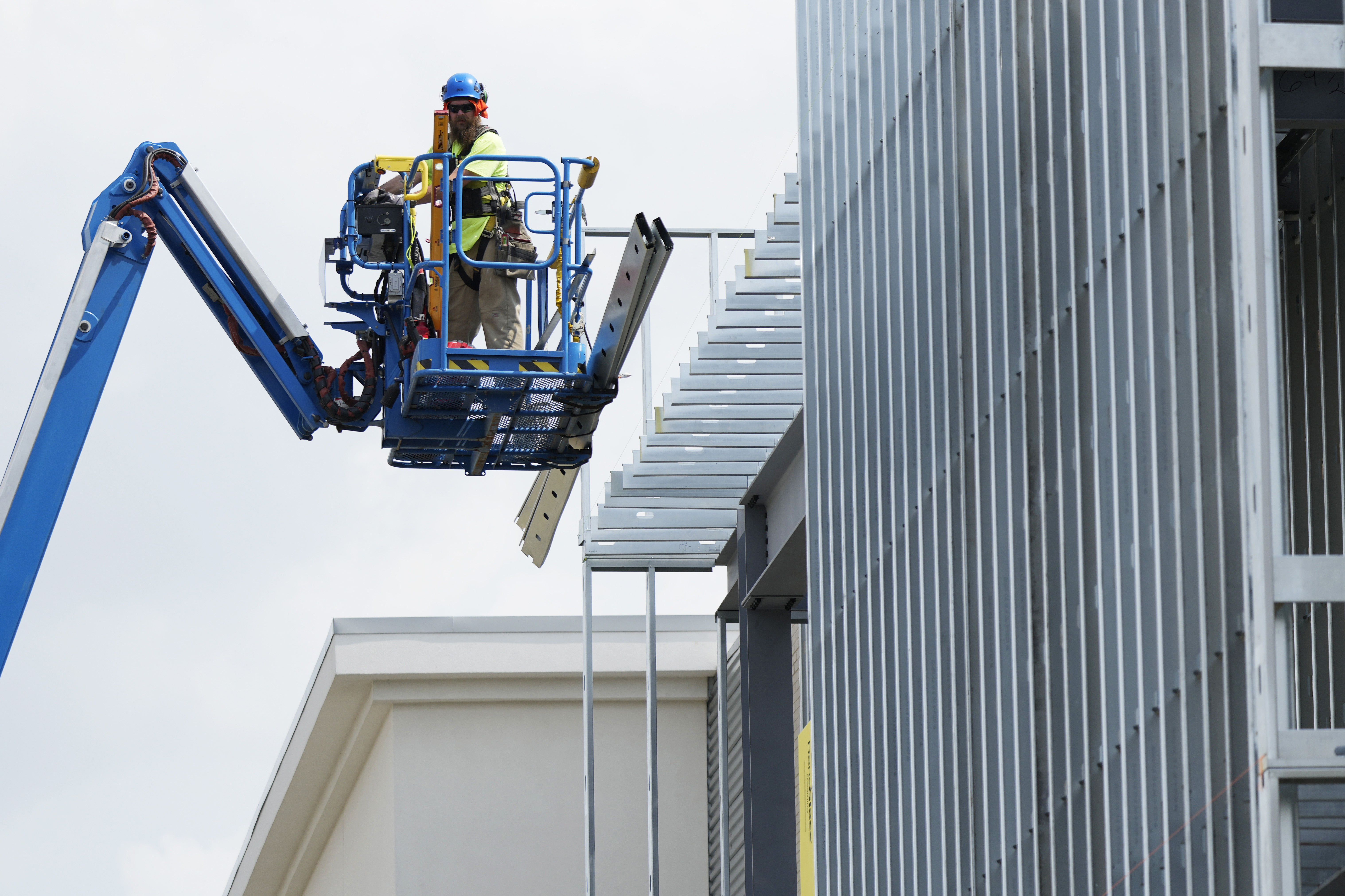 El trabajador de la construcción trabaja fuera del sitio de construcción comercial durante un clima cálido en Mount Prospect, Illinois.