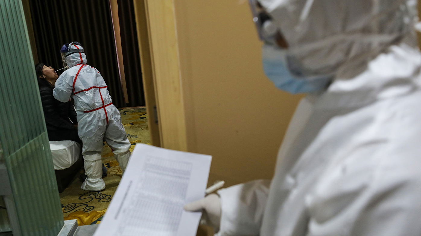 This photo taken on February 4, 2020 shows a medical staff member (L) taking samples from a person to be tested for the new coronavirus at a quarantine zone in Wuhan, the epicentre of the outbreak, in China's central Hubei province. . (Photo by STR / AFP) / China OUT (Photo by STR/A