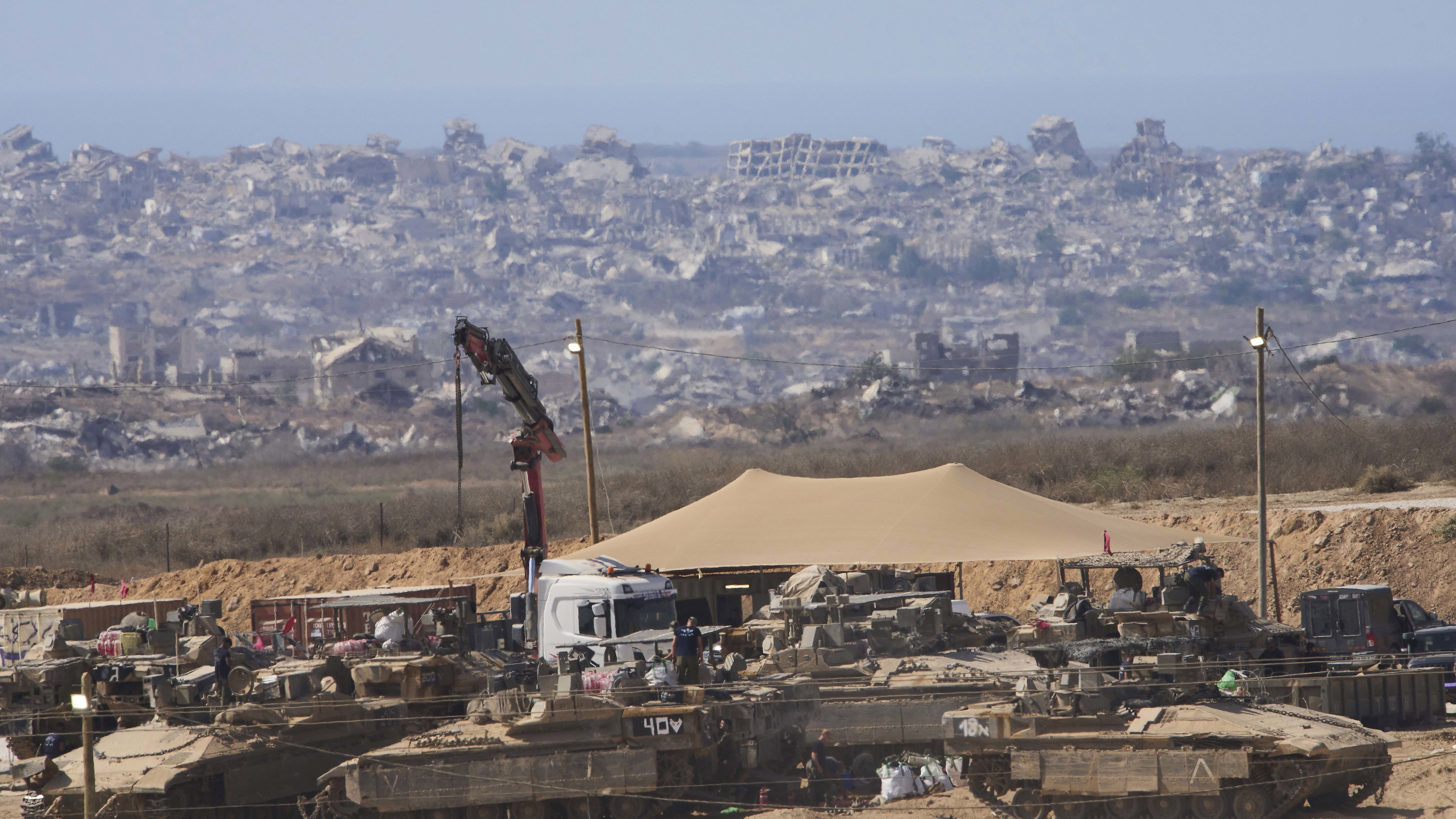 Israeli soldiers work on their tanks at a staging area on the border with Gaza Strip, in southern Israel, Tuesday, Sep. 9 2025. (AP Photo/Ariel Schalit)
