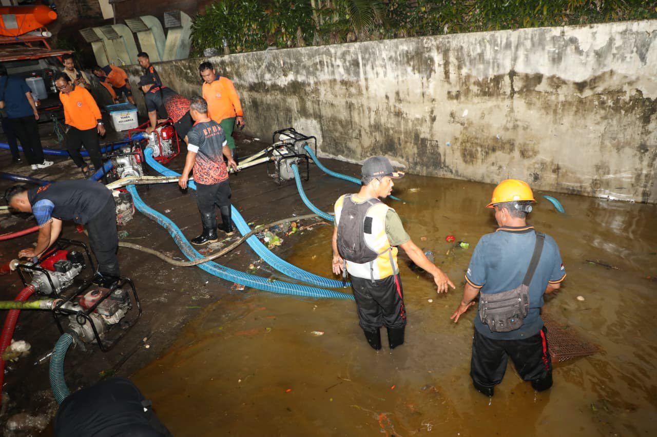 Clean-up teams in suctioning the water that is still held in the parking lot of Pasar Badung.
