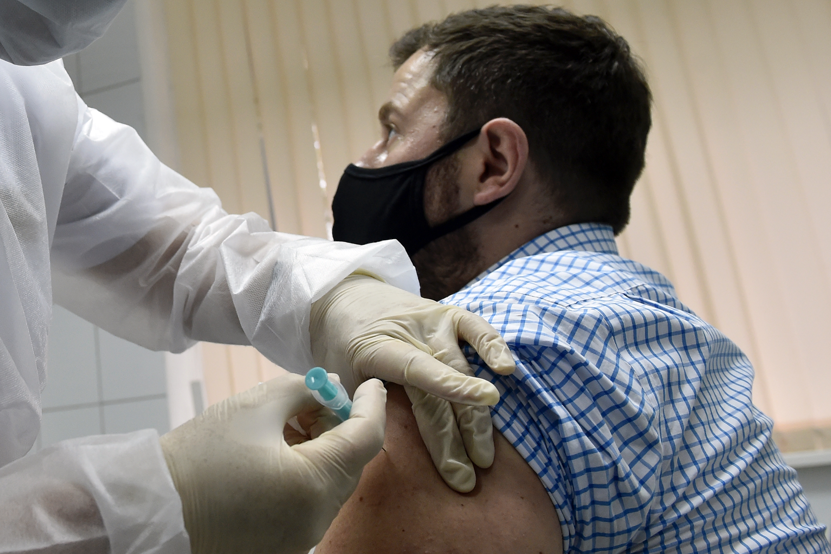 A nurse inoculates volunteer Ilya Dubrovin, 36, with Russia's new coronavirus vaccine in a post-registration trials at a clinic in Moscow on September 10, 2020. 