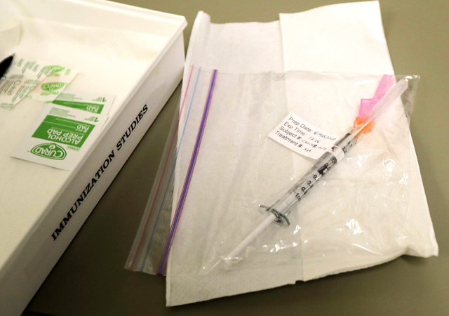 A syringe containing the first shot given in the first-stage safety study clinical trial of a potential vaccine for COVID-19, the disease caused by the new coronavirus, rests on a table