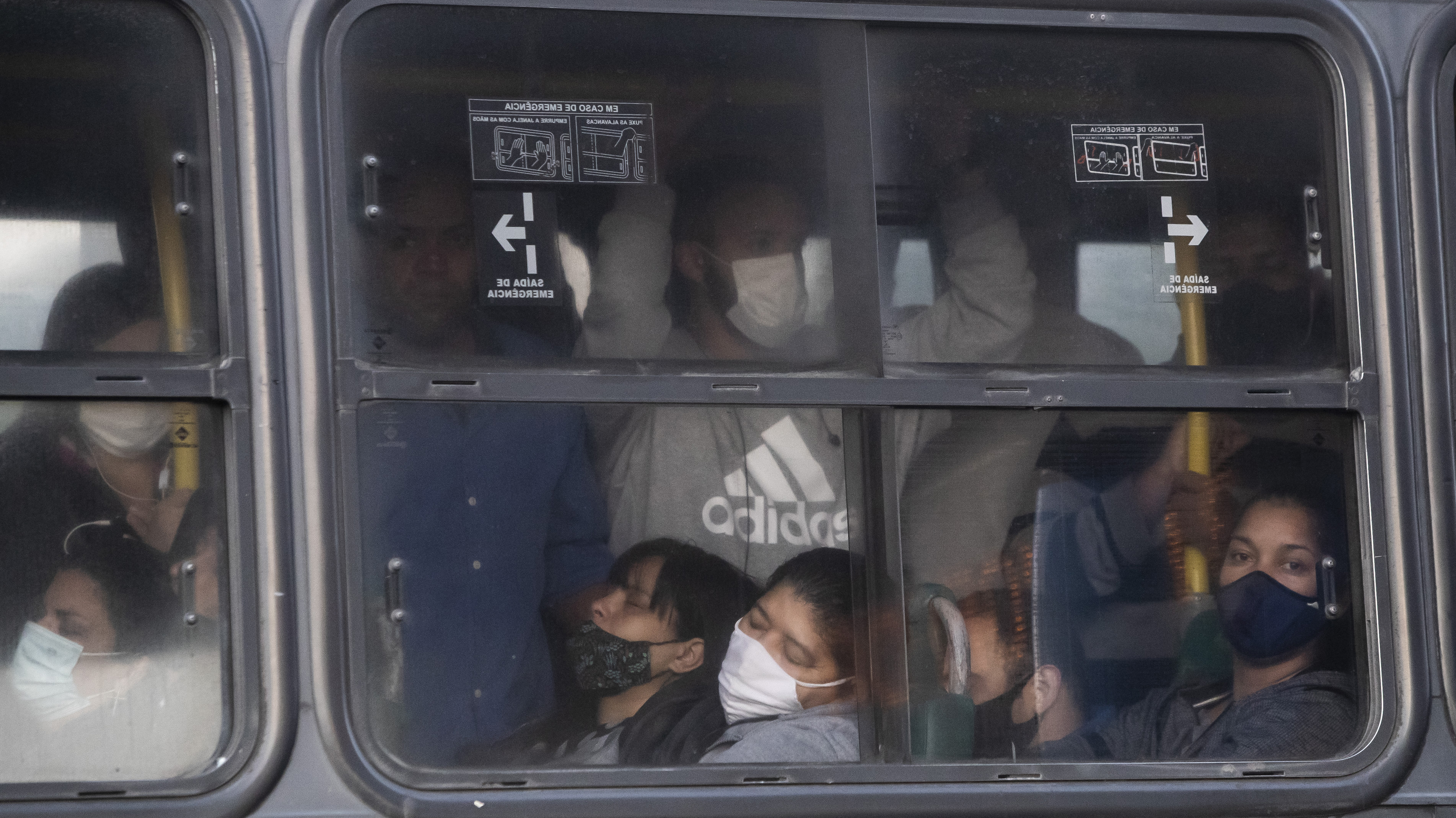 Commuters crowd a bus during the COVID-19 pandemic in Rio de Janeiro.