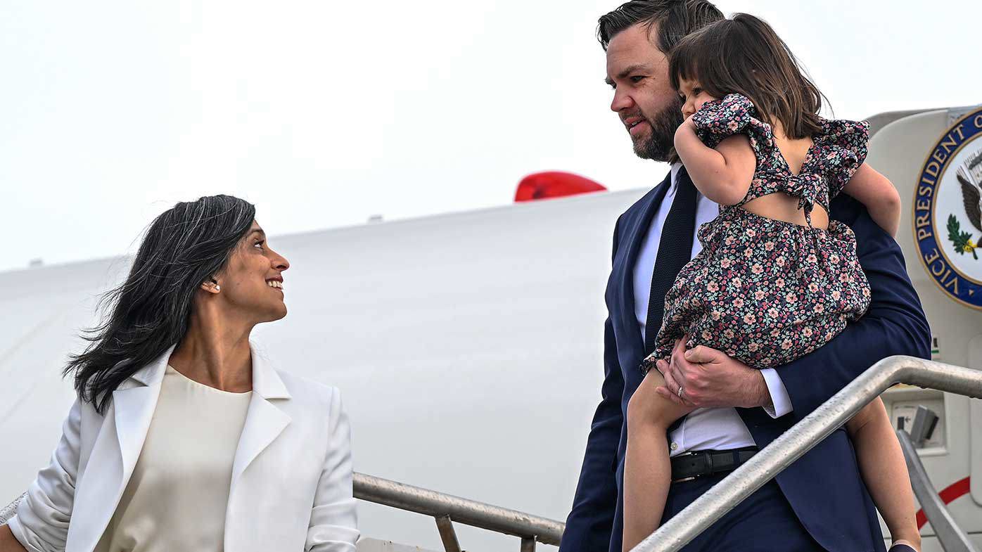 Second Lady Usha Vance looks back at Vice President JD Vance, carrying their daughter Mirabel as they disembark Air Force Two.