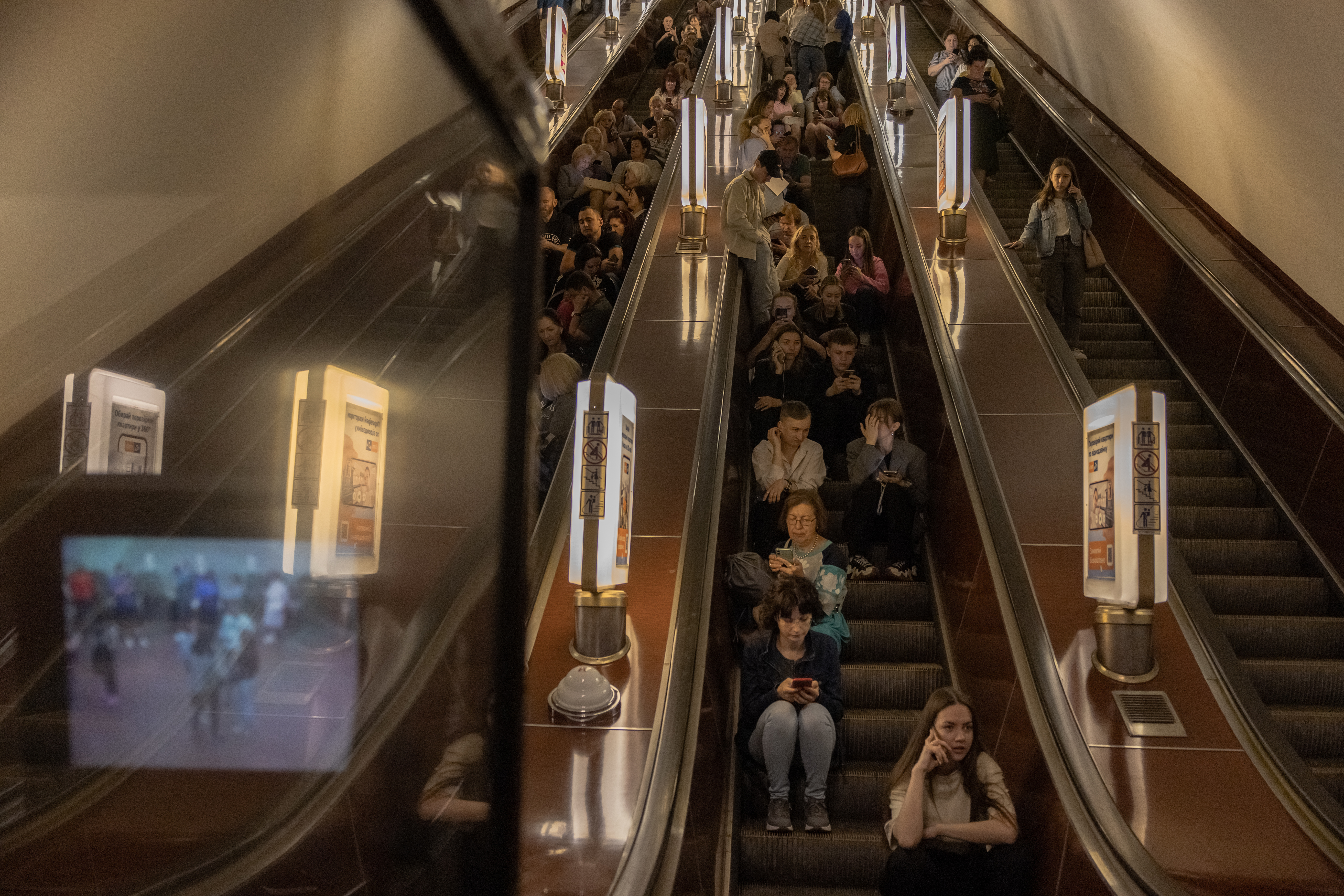 People sit on an escalator as they shelter in a subway station during Russian missiles attack on May 29, 2023 in Kyiv, Ukraine. 