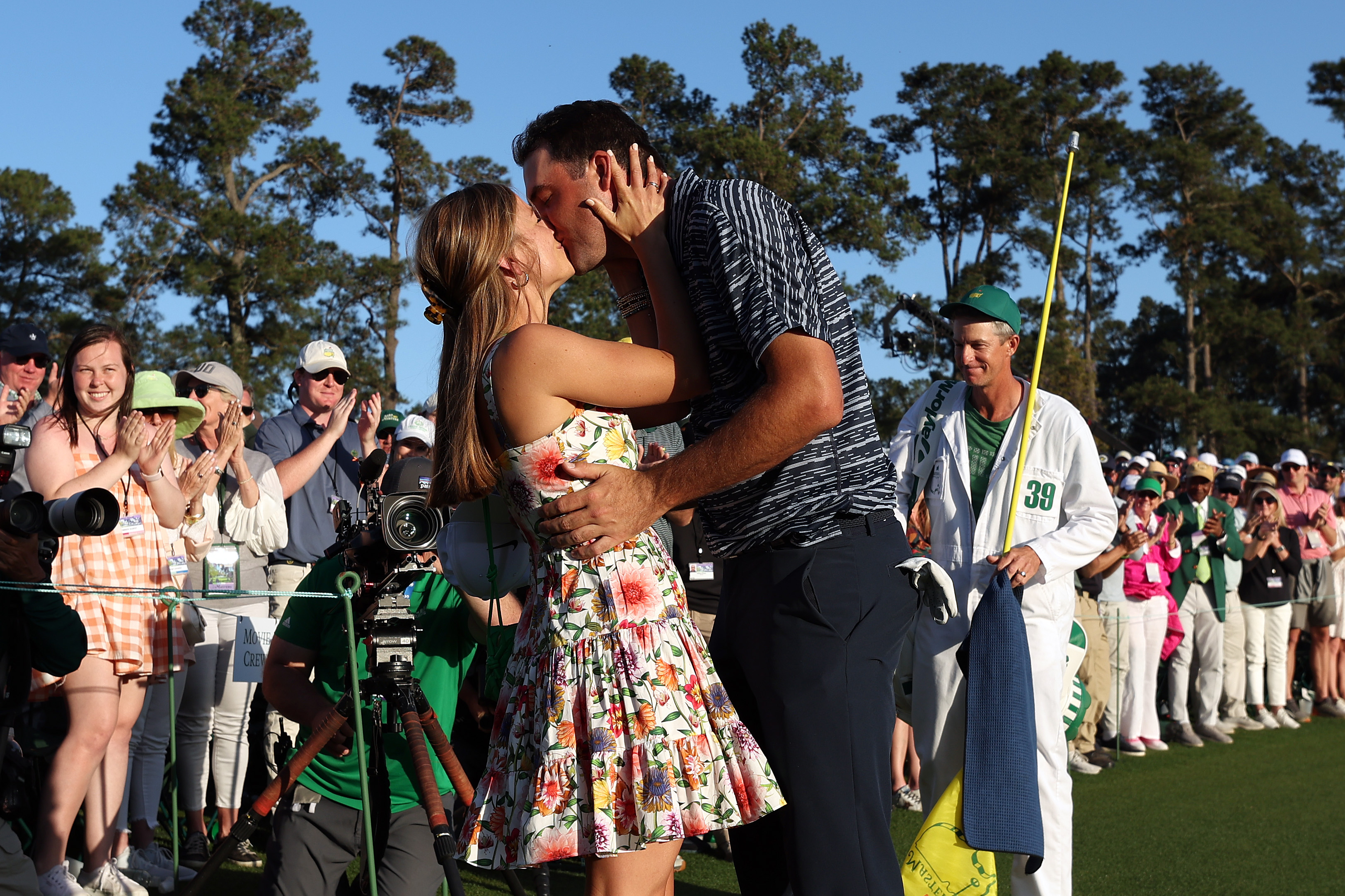 Scottie Scheffler and wife Meredith celebrate on the 18th green after Scheffler won the Masters at Augusta National Golf Club.