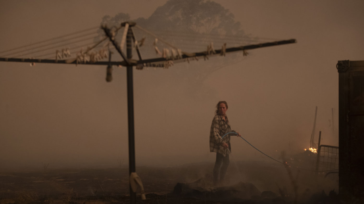 Clair Cowie defends her home from an out of control spot fire on February 01, 2020 at Bredbo North near Canberra, 