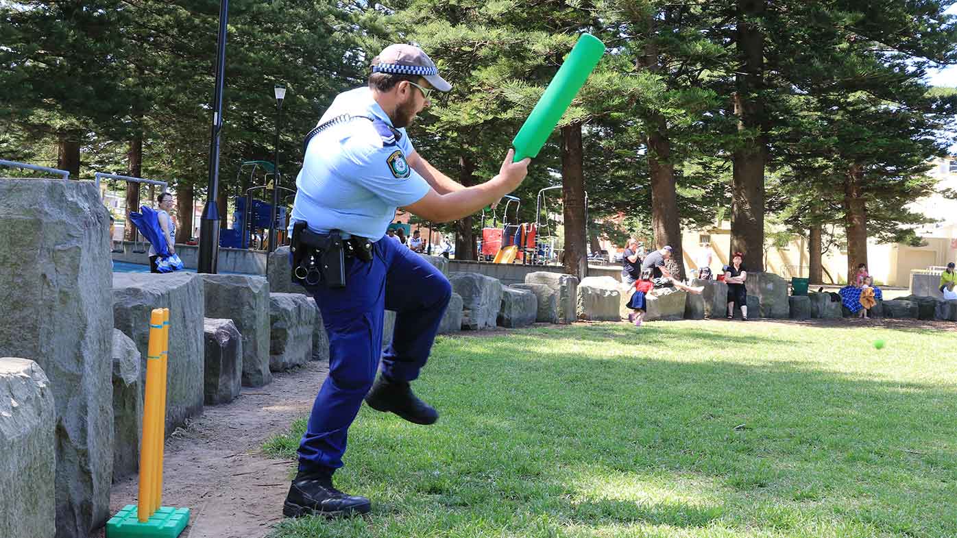 A policeman plays cricket at Cronulla Beach in Sydney on Christmas Day.