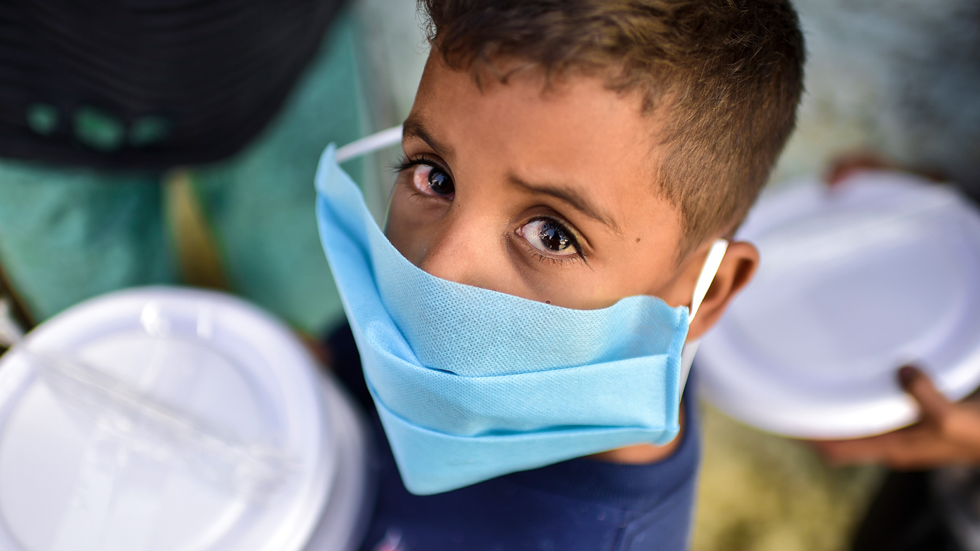  A young boy from a Brazilian favela lines up for a food donation. There has been a spike in deaths of children as the Gamma variant surges in the country.