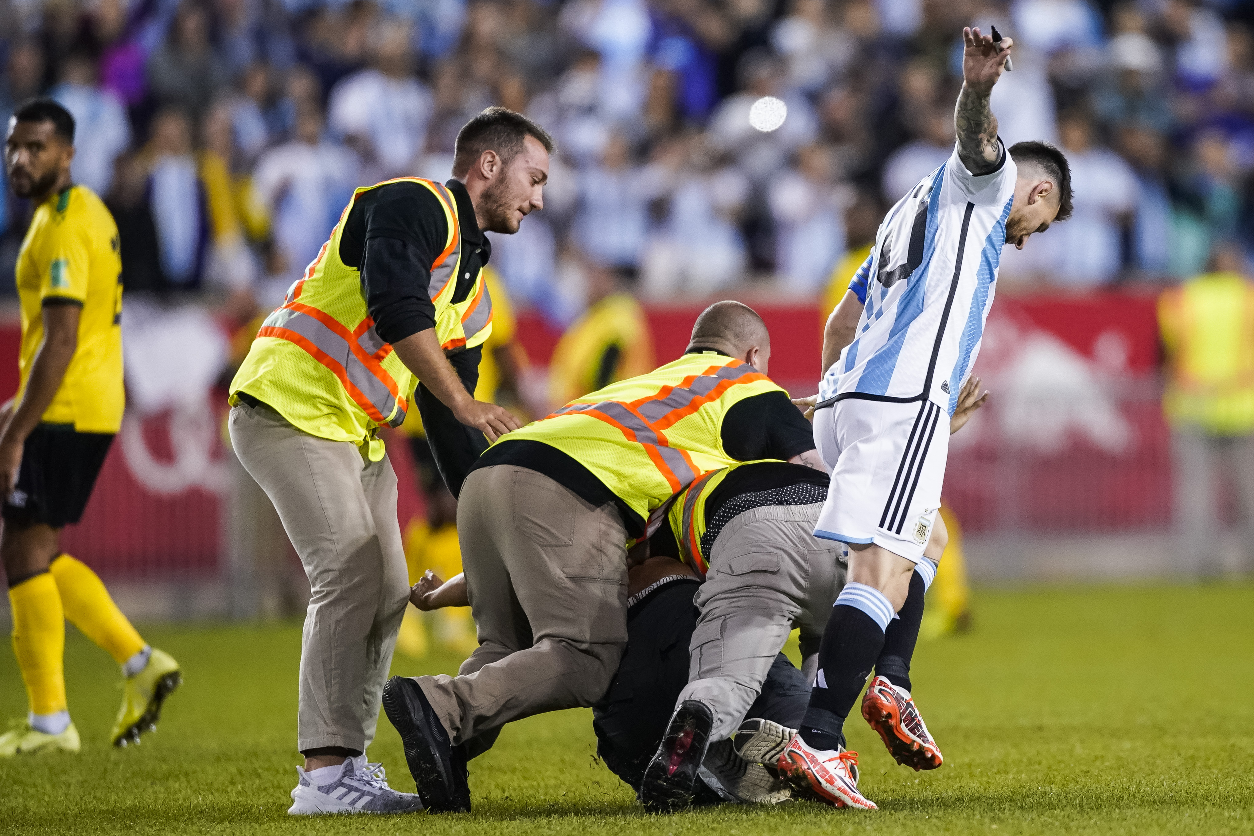 A fan is tackled as he tries to take a selfie with Argentina's Lionel Messi.