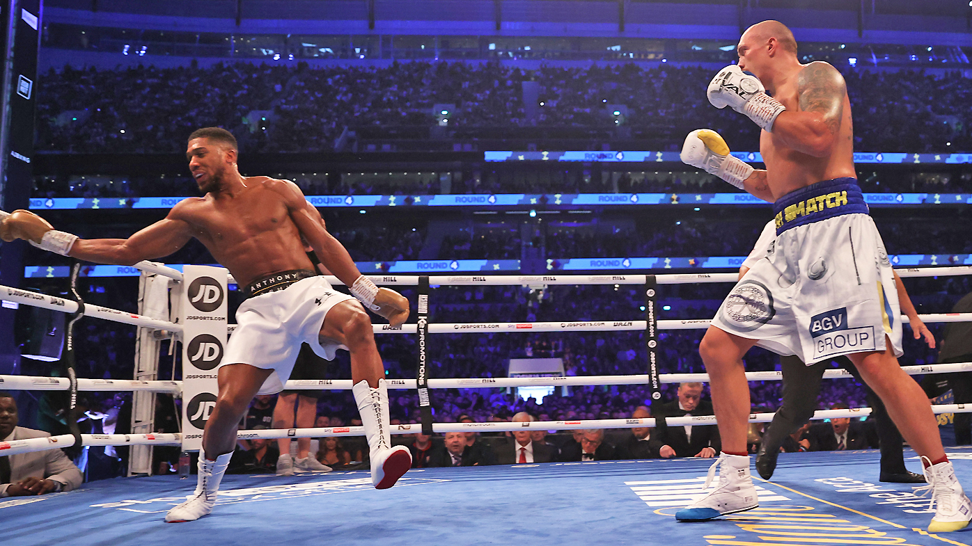 Oleksandr Usyk looks on as Anthony Joshua stumbles