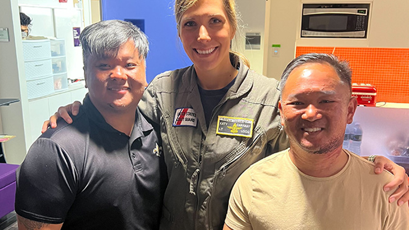 Coast Guard Lt. Katy Caraway reunites with survivors Phong Le, left, and Luan Nguyen.