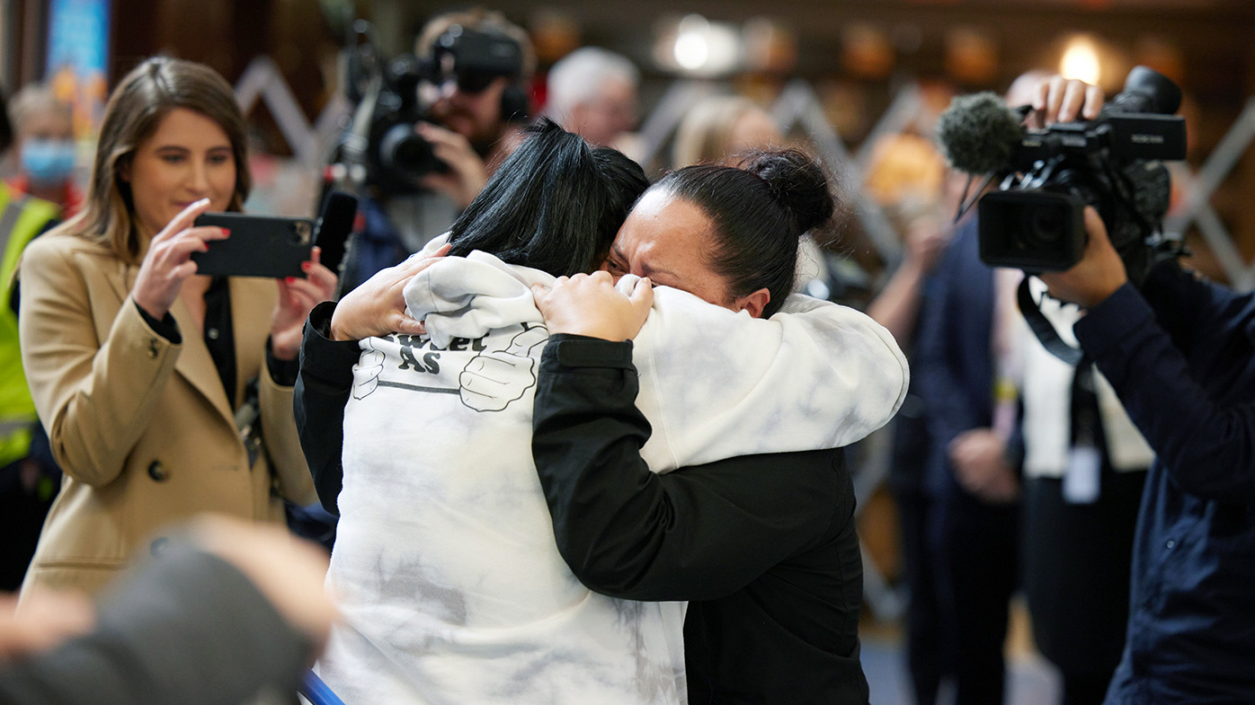 People embrace as they are reunited at Auckland International Airport in Auckland yesterday.
