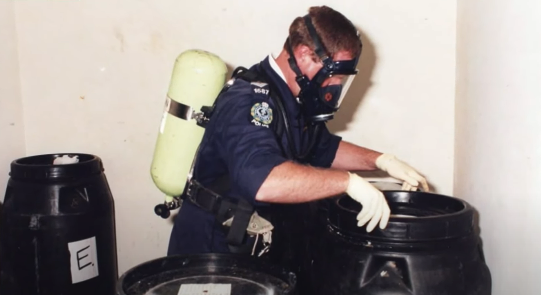 A police officer examines barrels in the Snowtown killings.