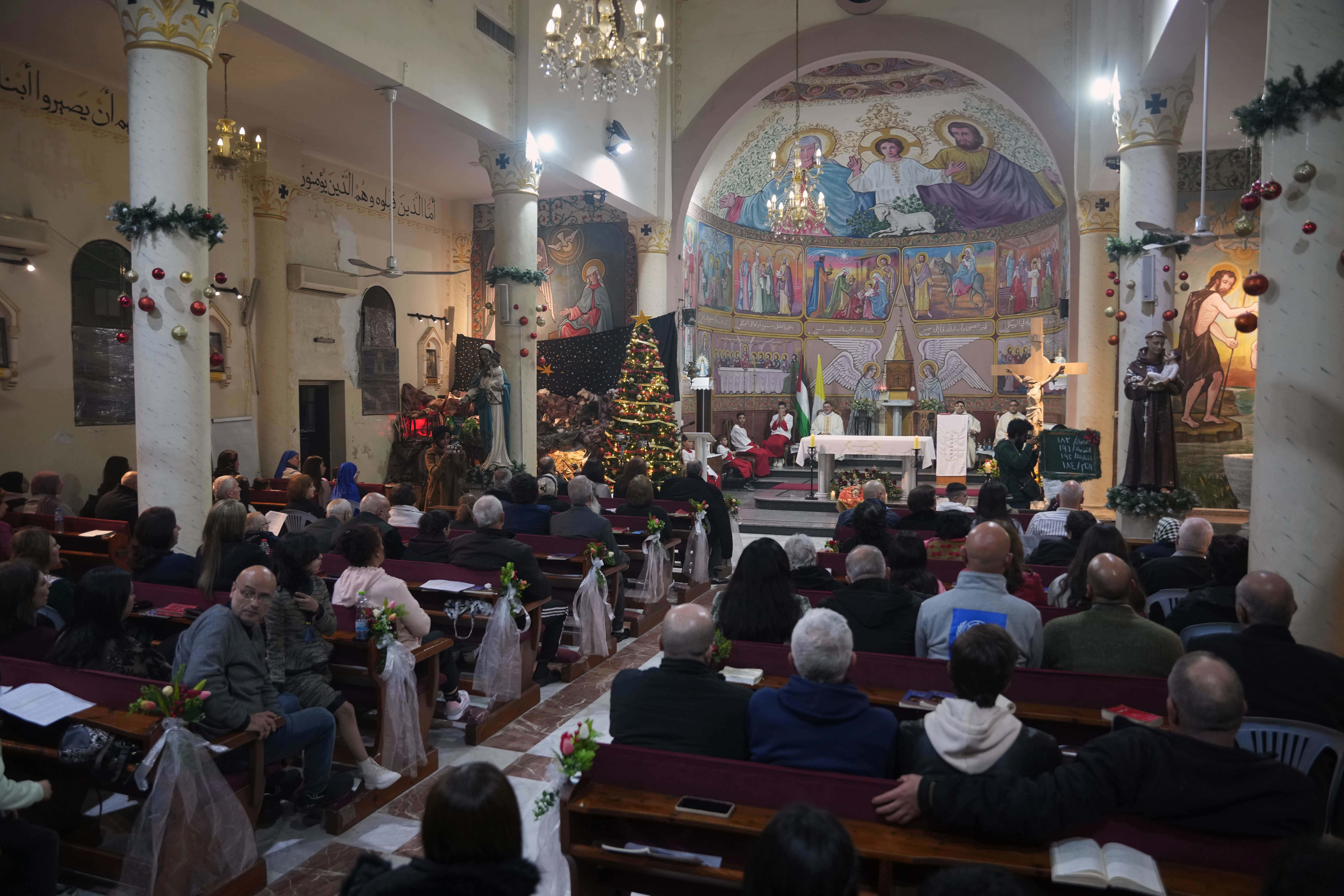 Palestinian Christians attend Mass on Christmas Eve at the Holy Family Catholic Church in Gaza City