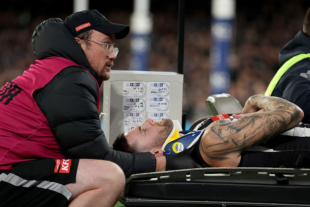 Jeremy Howe of the Magpies leaves the ground on a stretcher.