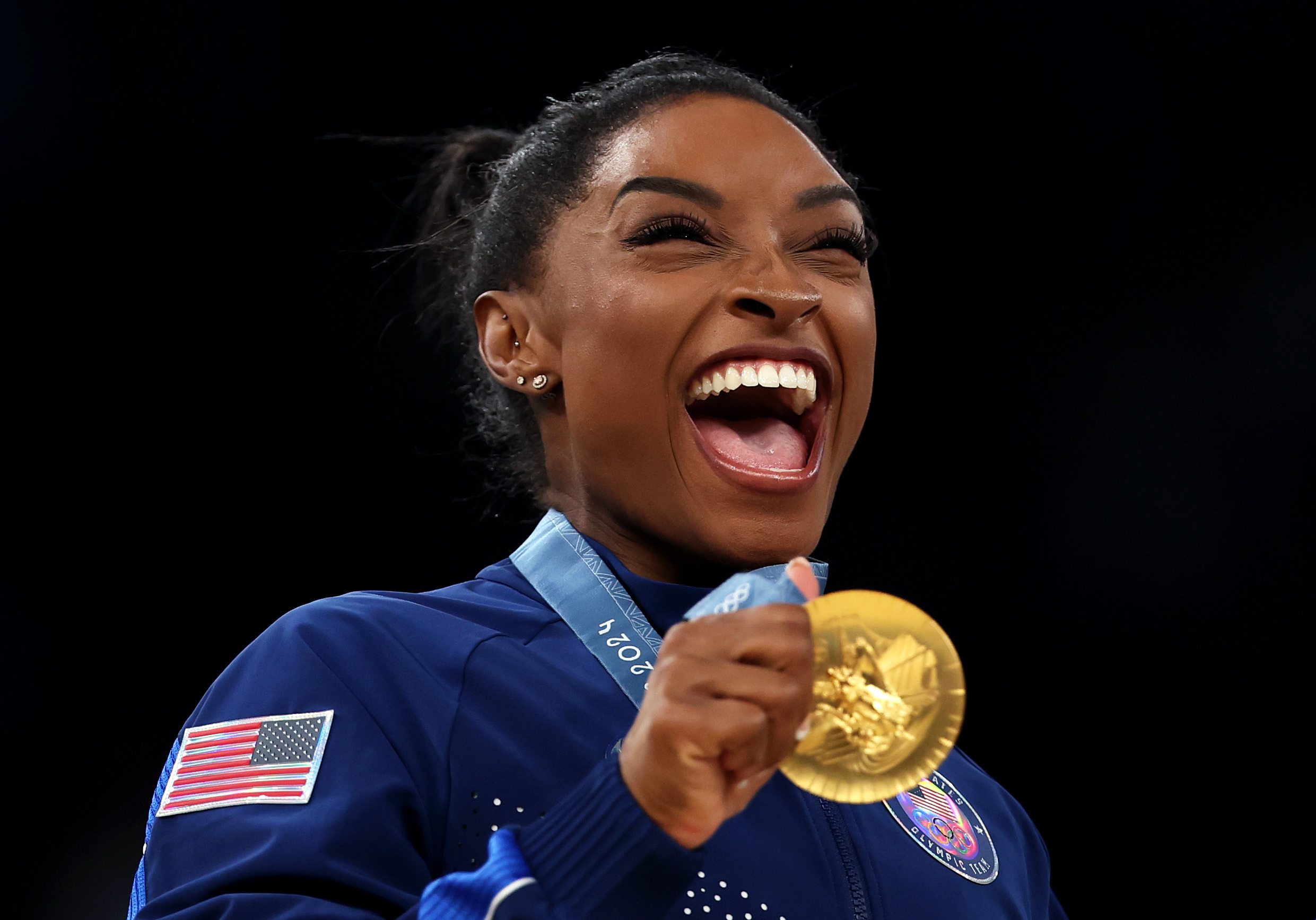 La medallista de oro Simone Biles del equipo de Estados Unidos celebra en el podio.