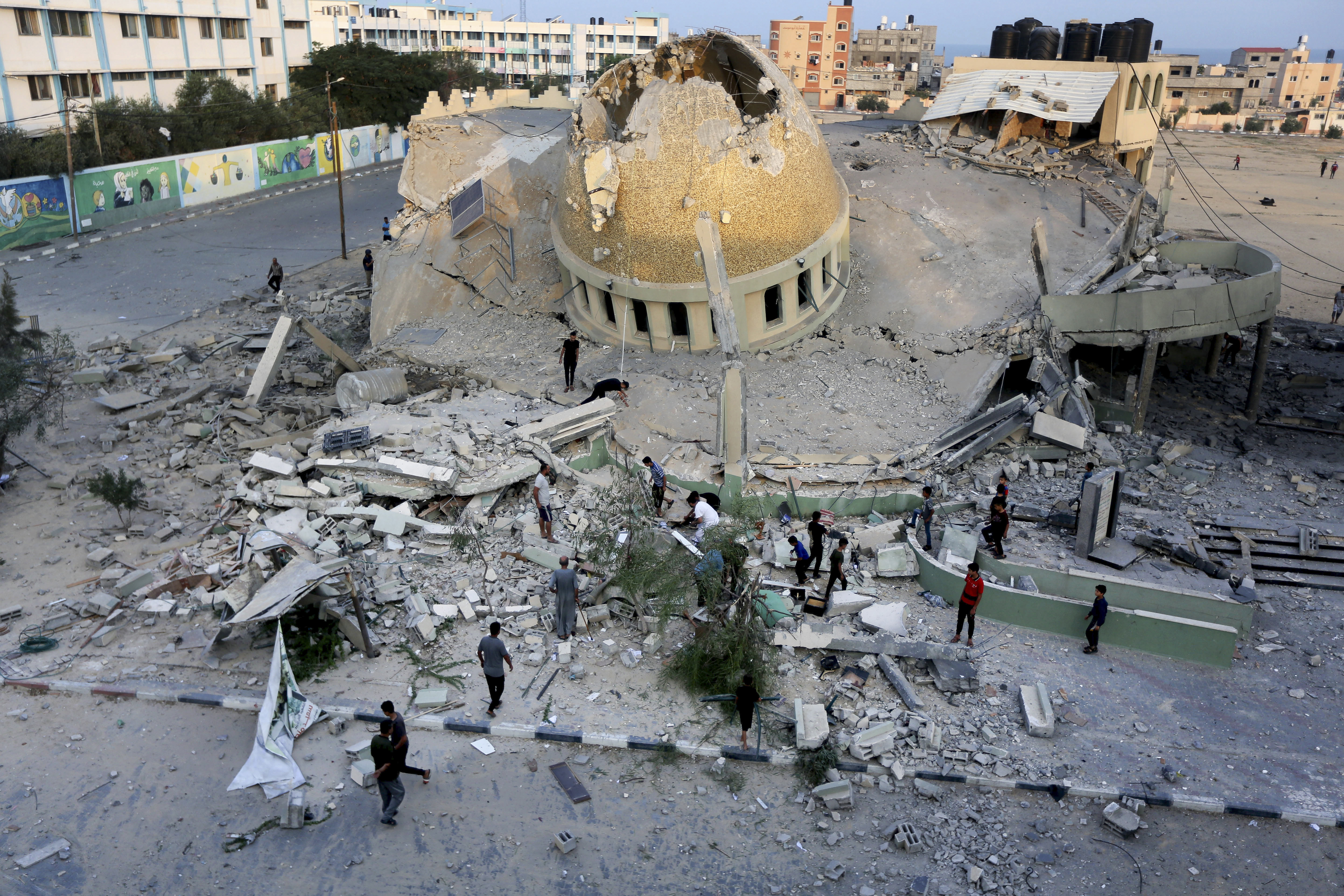 People stand outside a mosque destroyed in an Israeli air strike in Khan Younis, Gaza Strip.