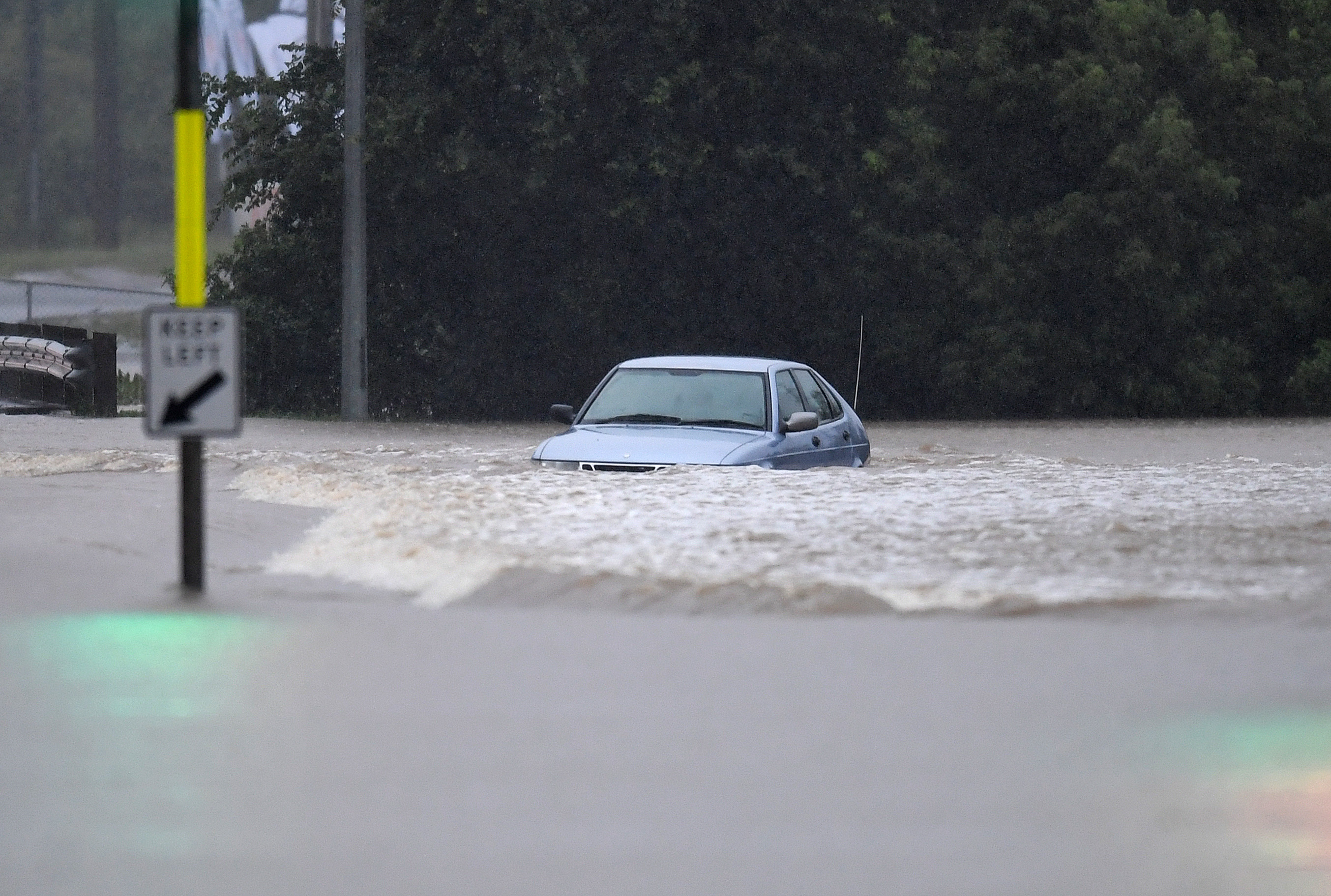 A vehicle is submerged in flood water in the suburb of Oxley in Brisbane. 