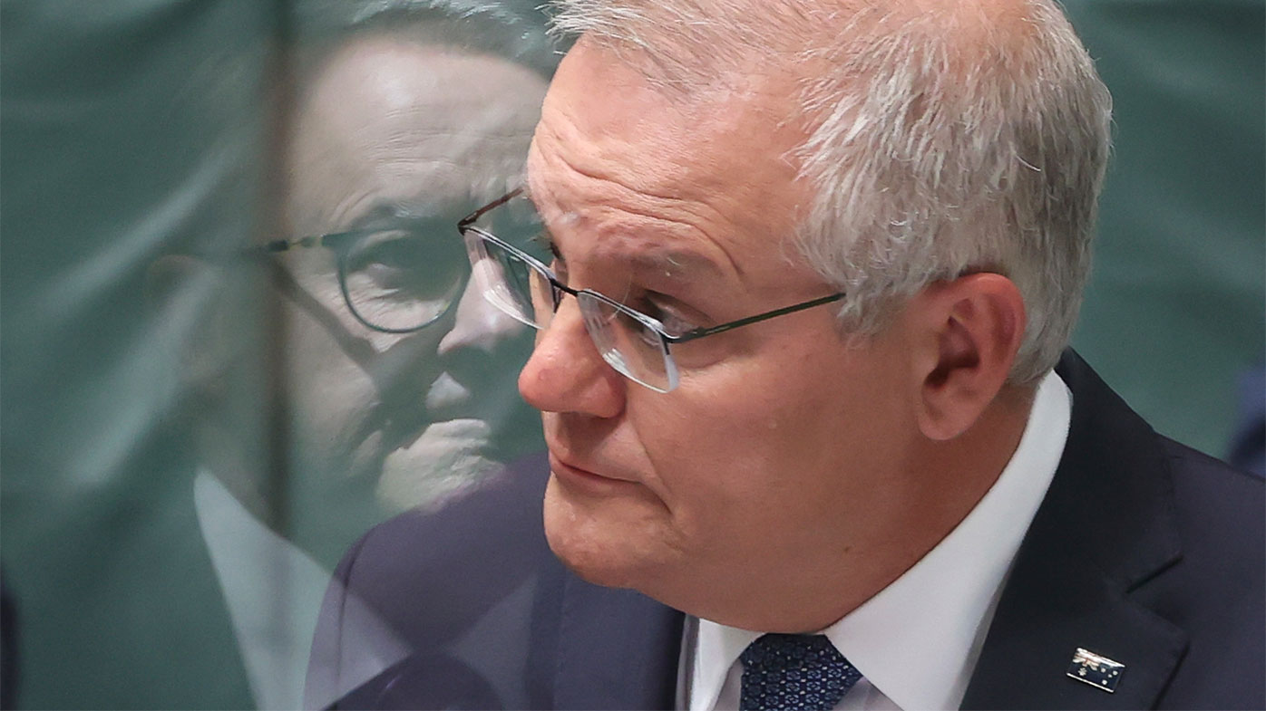Anthony Albanese's reflection is seen on the Perspex barrier between him and Scott Morrison in Parliament.
