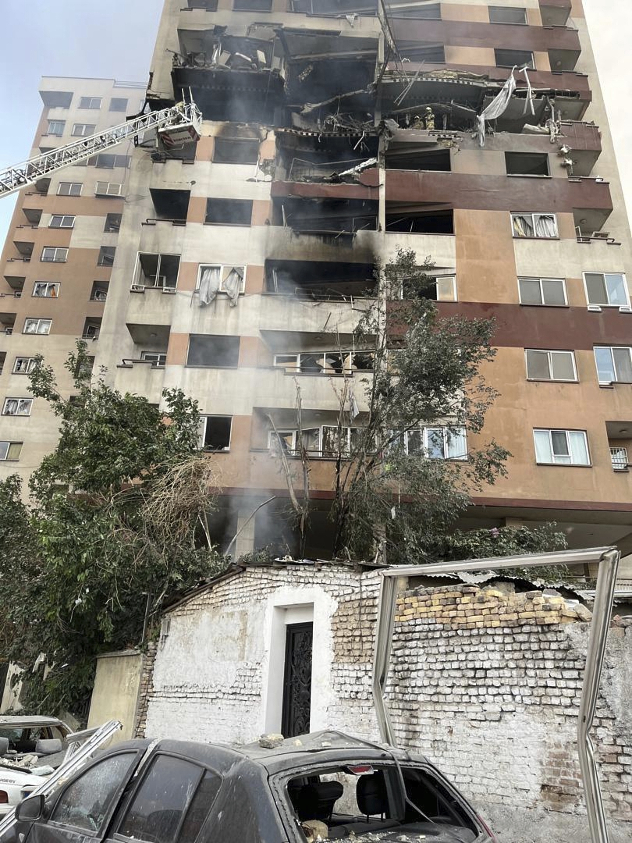 Firemen work at an apartment building after it was hit in Tehran.