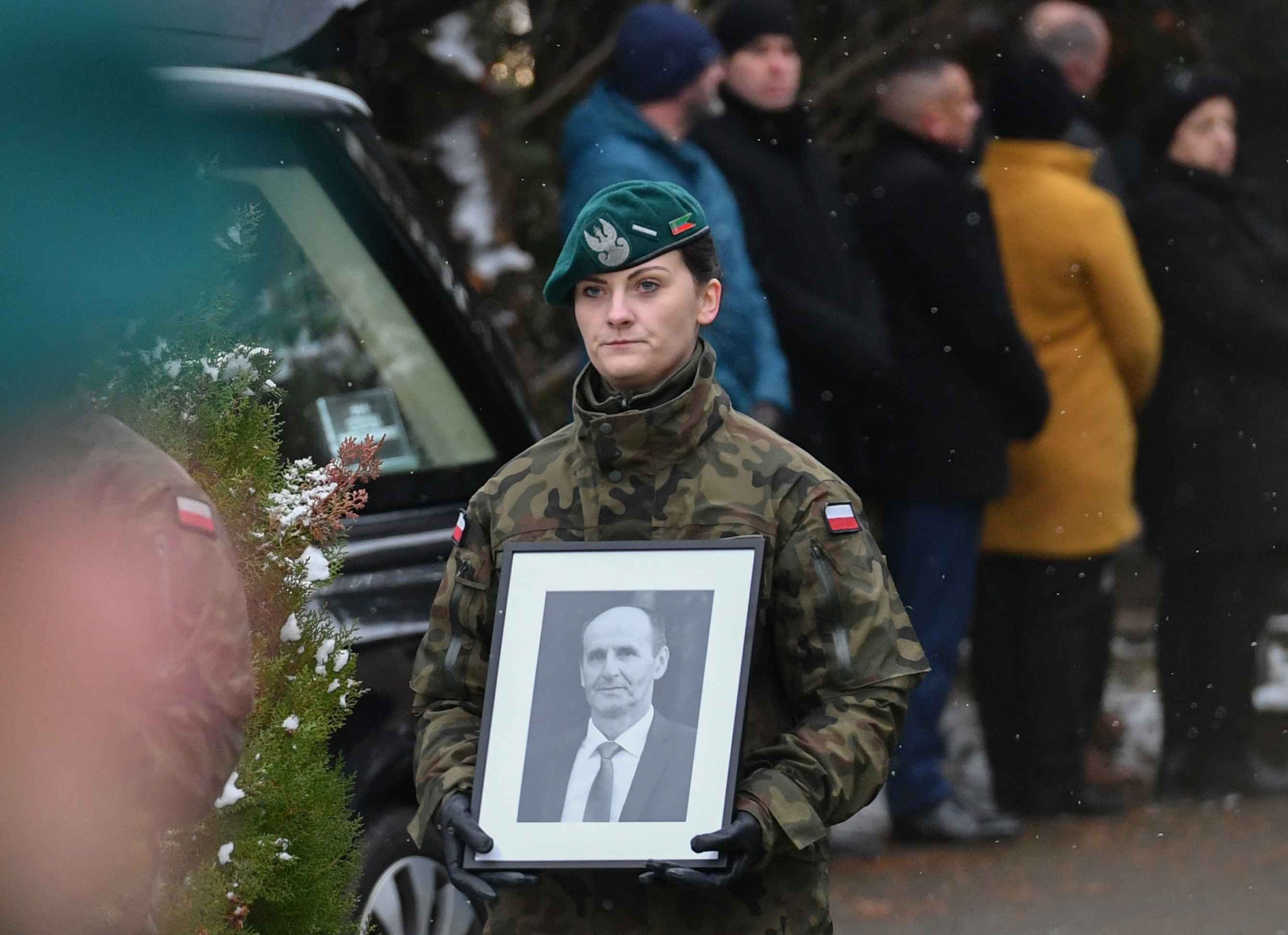 A Polish Border Guard official carries a photograph of Boguslaw Wos, one of two Polish men killed in a missile explosion, ahead of his funeral, in Przewodow, Poland, Saturday, Nov. 19, 2022. A funeral for Wos was held on Saturday. Western officials said the deaths appeared to have been caused by a Ukrainian air defense missile that went astray as the country was defending itself against a barrage of Russian missiles directed at Ukraines power infrastructure. (AP Photo)