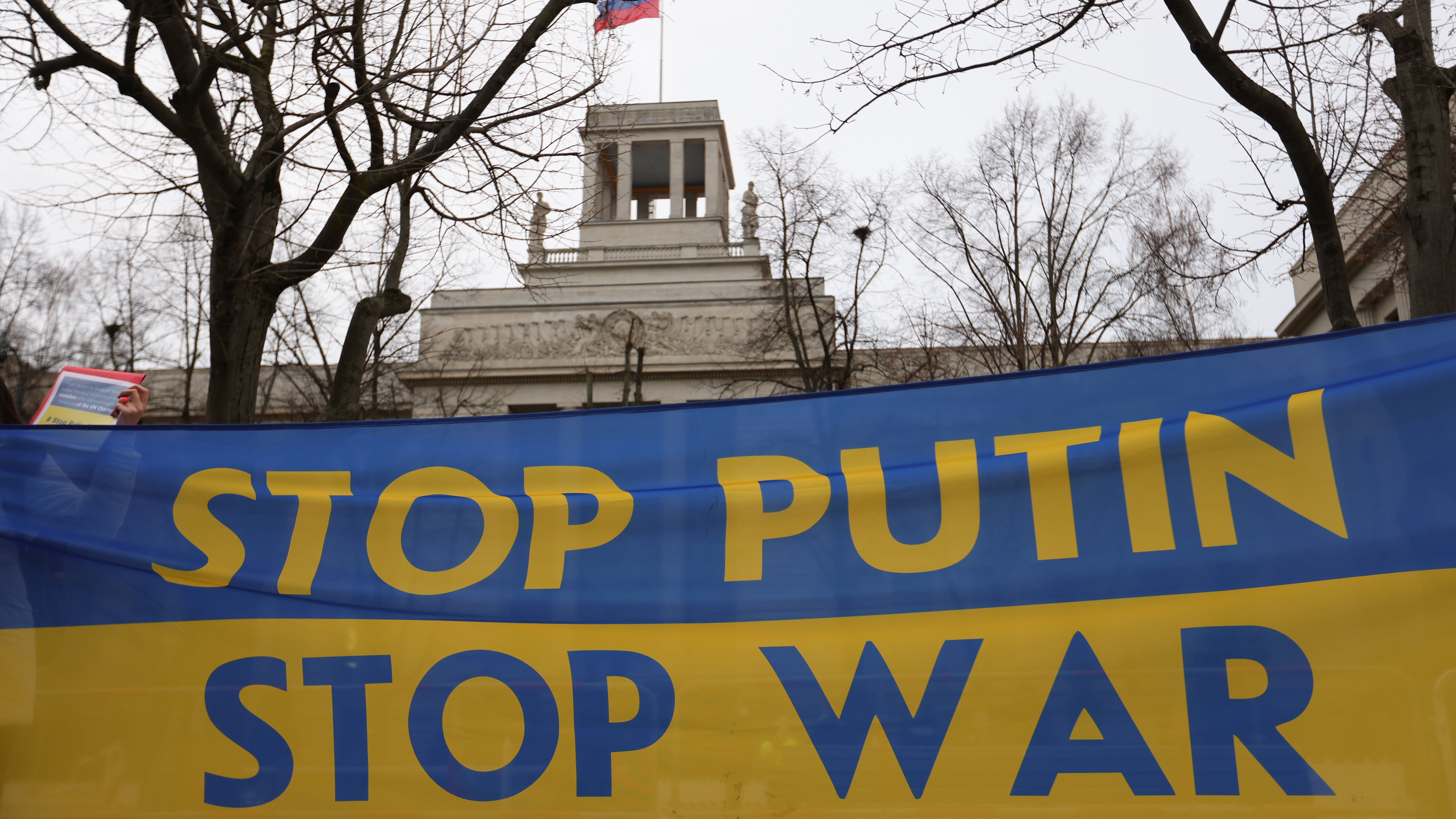 Protesters hold a banner reading stop Putin stop war in Berlin, Germany. 