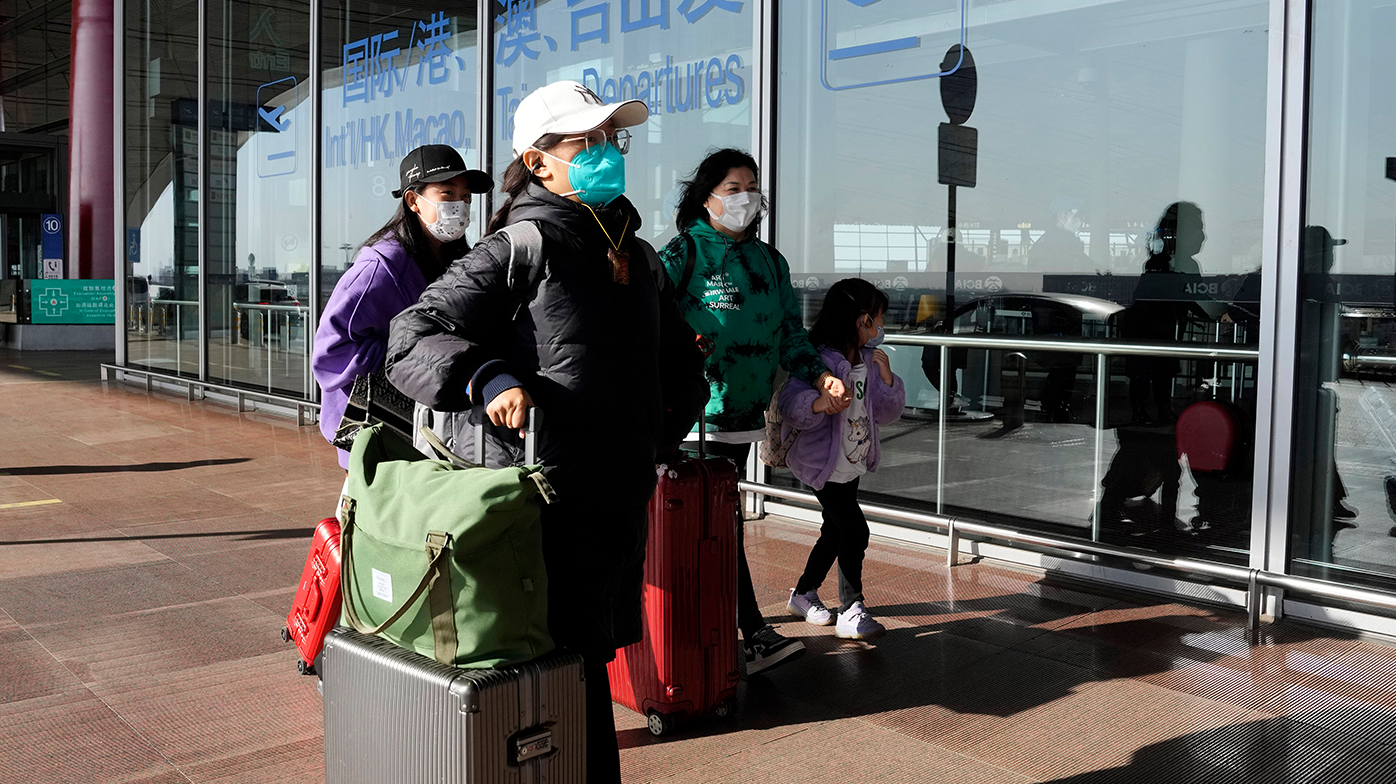 Pasajeros con máscaras caminan por la terminal del aeropuerto de Capital en Beijing el 13 de diciembre de 2022.