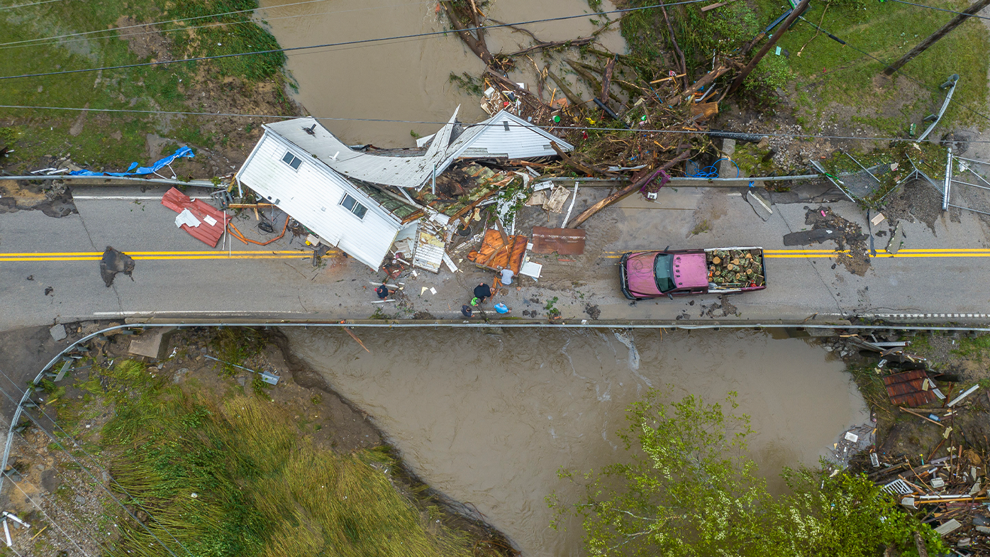 People work to clear a house from a bridge near the Whitesburg Recycling Center in Letcher County, Kentucky on Friday, July 29, 2022. (Ryan C. Hermens/Lexington Herald-Leader via AP)