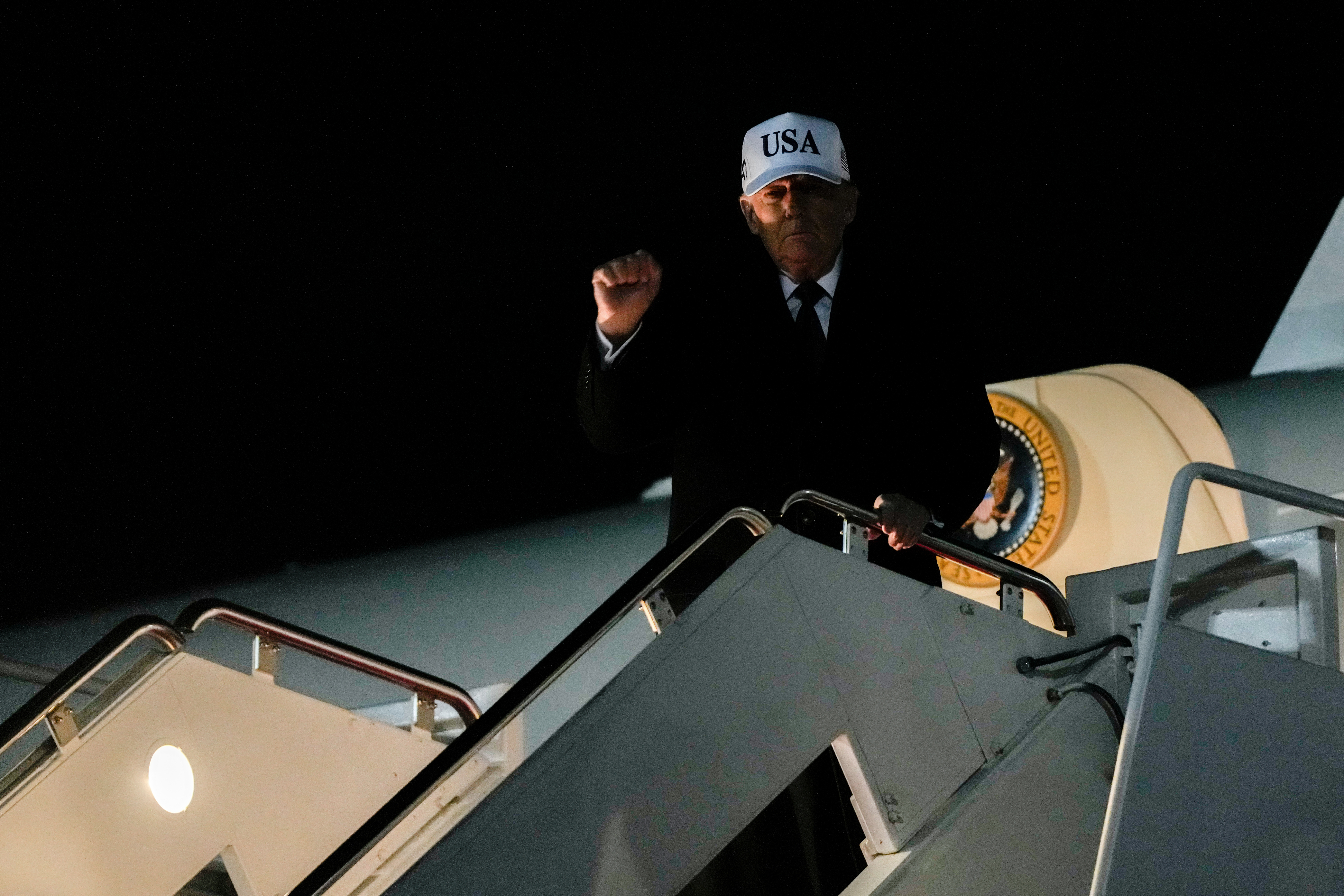 US President Donald Trump gestures while disembarking Air Force One after returning from Florida, Sunday, Jan. 11, 2026.