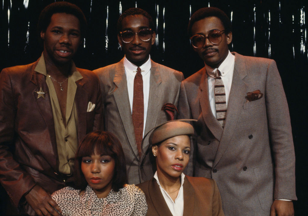 American band Chic on the set of a french tv show. In the background, from left to right : music producer, songwriter, composer, and arranger, Nile Rodgers, drummer Tony Thompson, bassist and also music producer, songwriter, and composer, Bernard Edwards. In the foreground, singers Luci Martin (L) and Alfa Anderson. France, 30th January 1979. (Photo by James Andanson/Sygma via Getty Images)