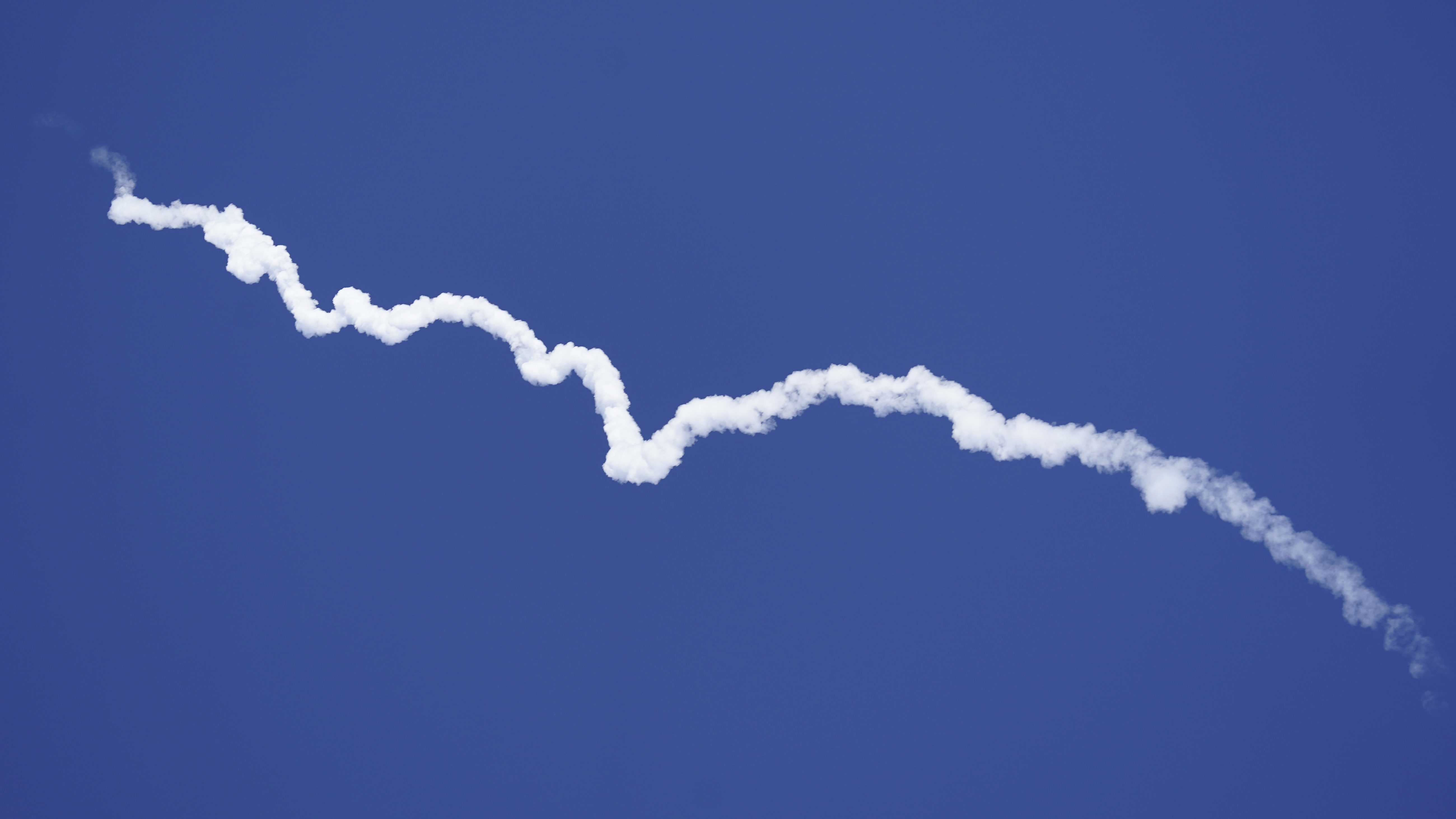 Blue Origin's New Shepard rocket leaves a smoke trail after lifting off.