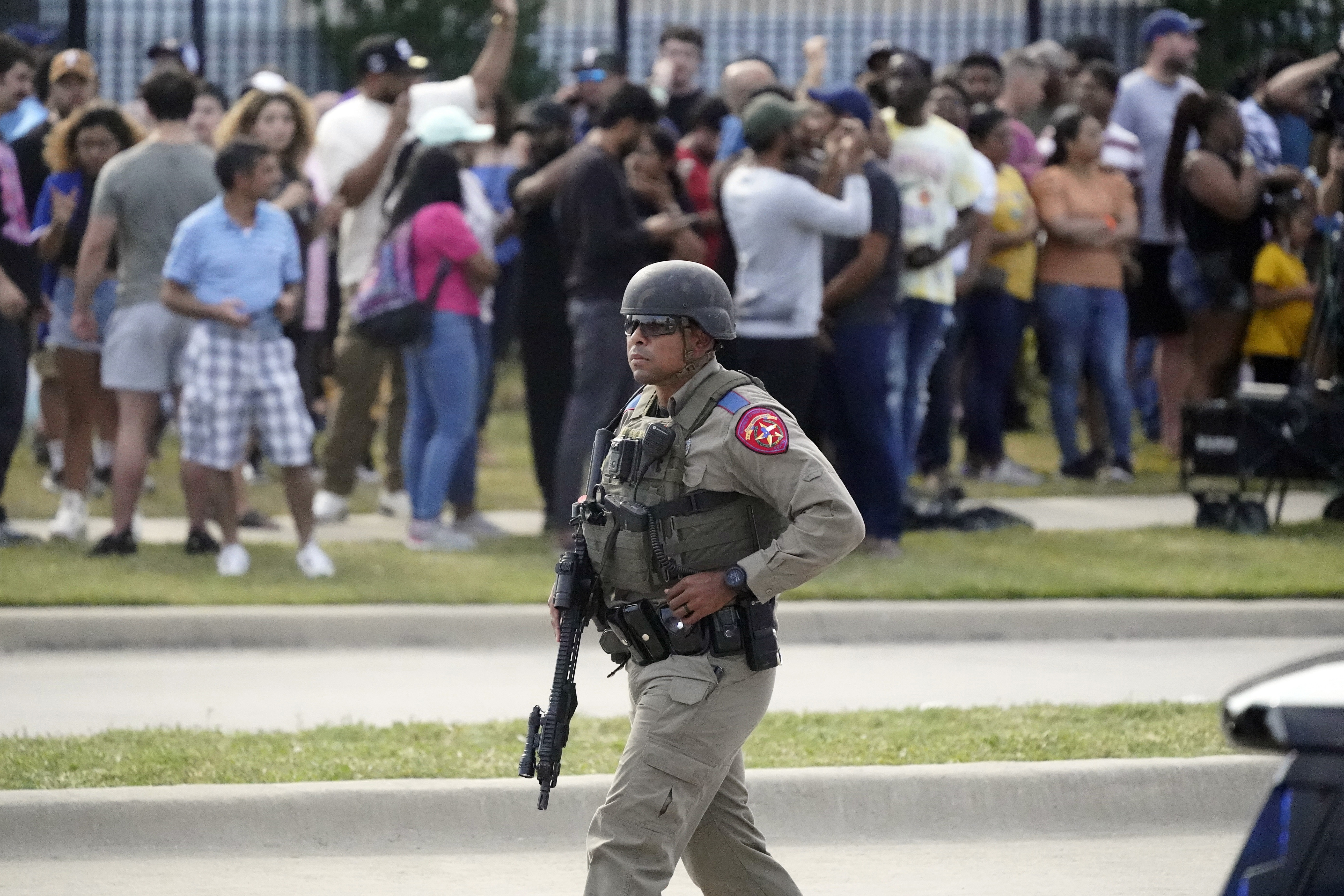 Un oficial de la ley camina mientras las personas son evacuadas de un centro comercial donde ocurrió un tiroteo el sábado 6 de mayo de 2023 en Texas. 