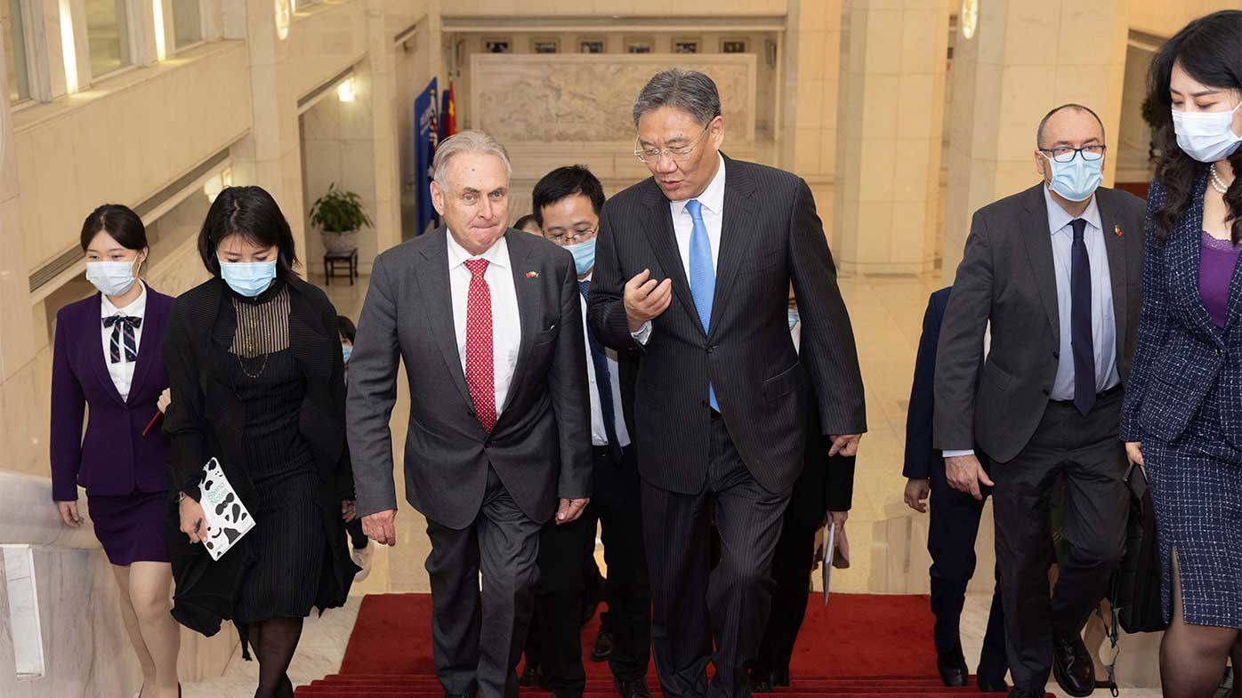 Australian Trade and Tourism Minister Don Farrell, left, arrives for a meeting with Chinese Minister of Commerce Wang Wentao, right, in Beijing.