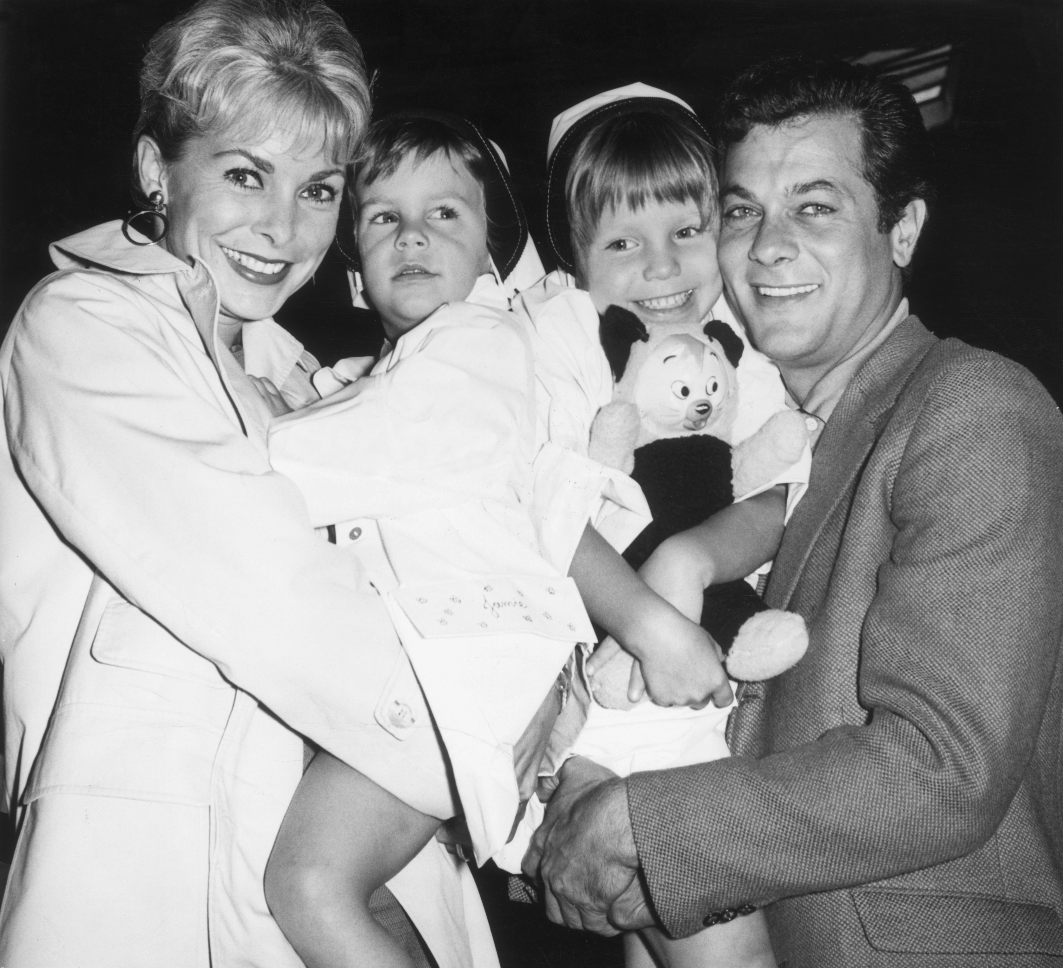 Married American actors Janet Leigh and Tony Curtis holding their daughters Kelly (right), 5, and Jamie Lee Curtis, 2, (left).