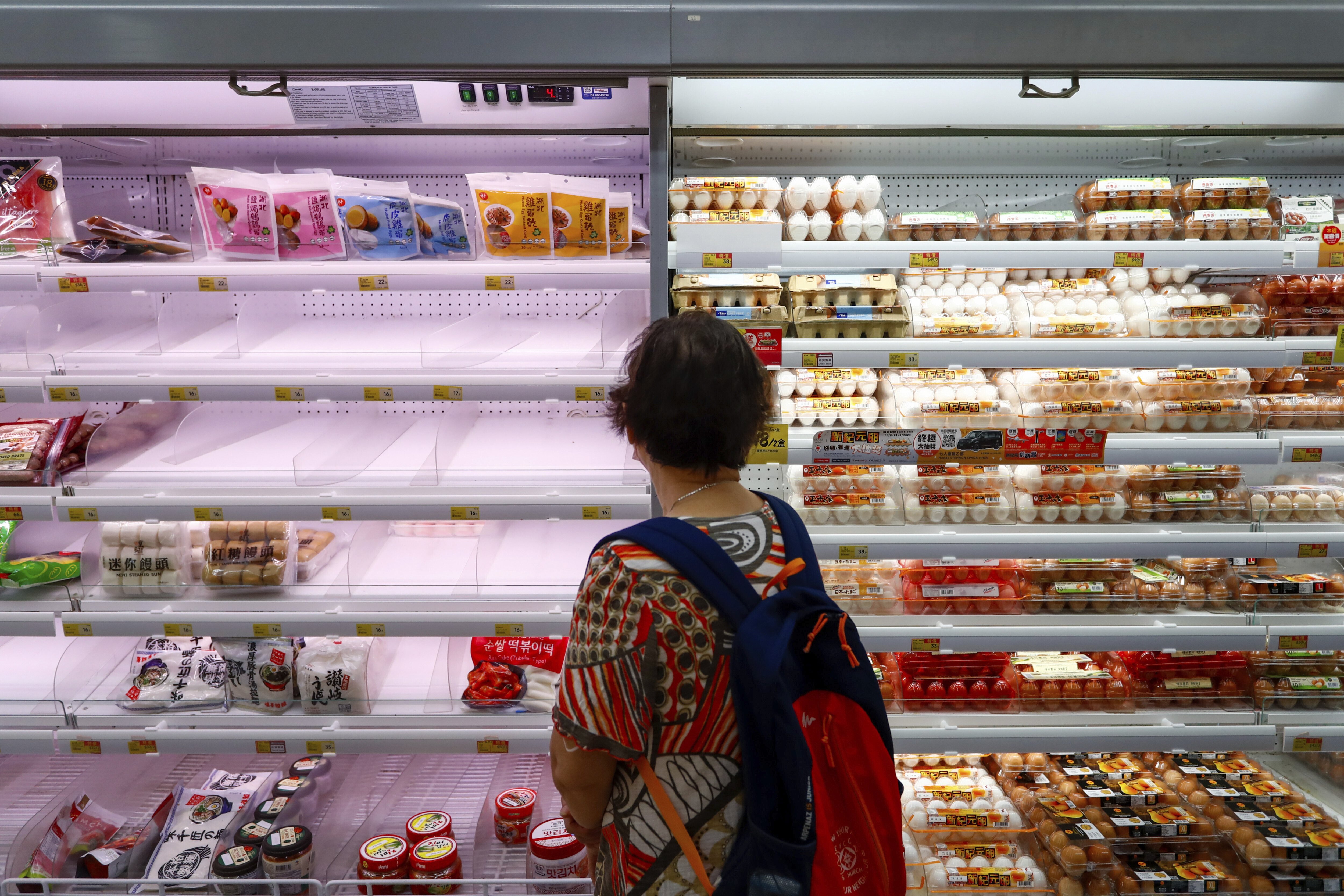 A shopper looks at near empty shelves at a supermarket as super typhoon Saola approaches Hong Kong on Friday, Sept. 1, 2023. 