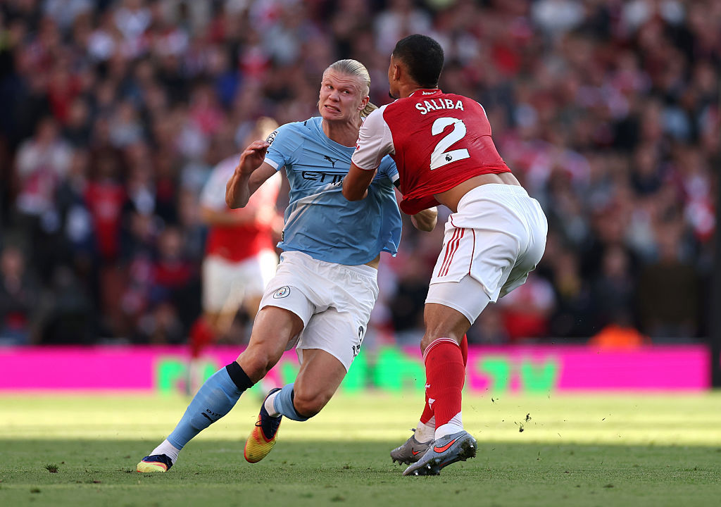 Erling Haaland of Manchester City and William Saliba of Arsenal battle for position.